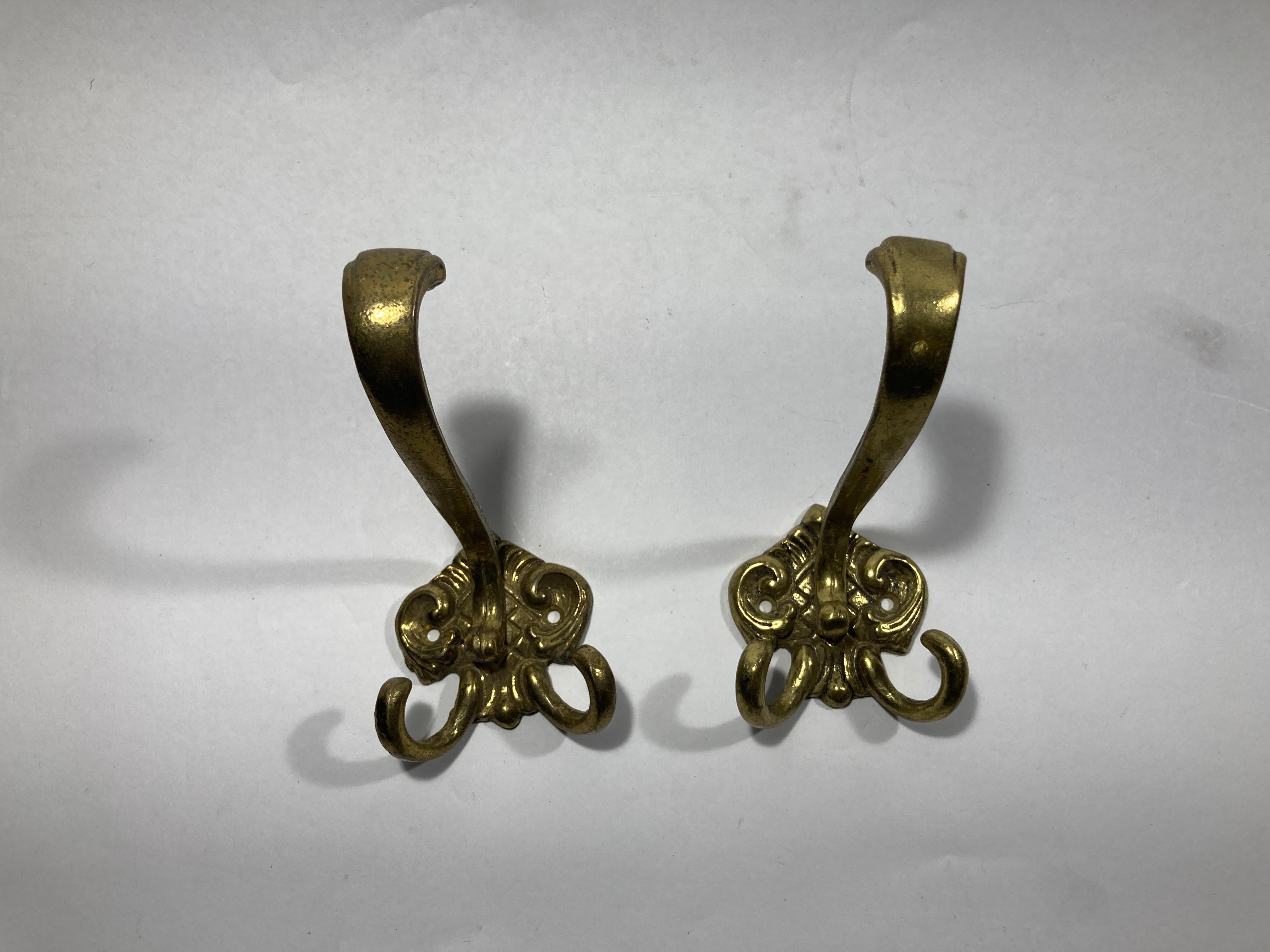 Set of two antique French cast brass double hook
Vintage French brass coat double hook dating from the early 1950s.
The hook are cast brass.
The hook is fastened to a shaped cartouche back plate and this has two fixing holes on either side, to