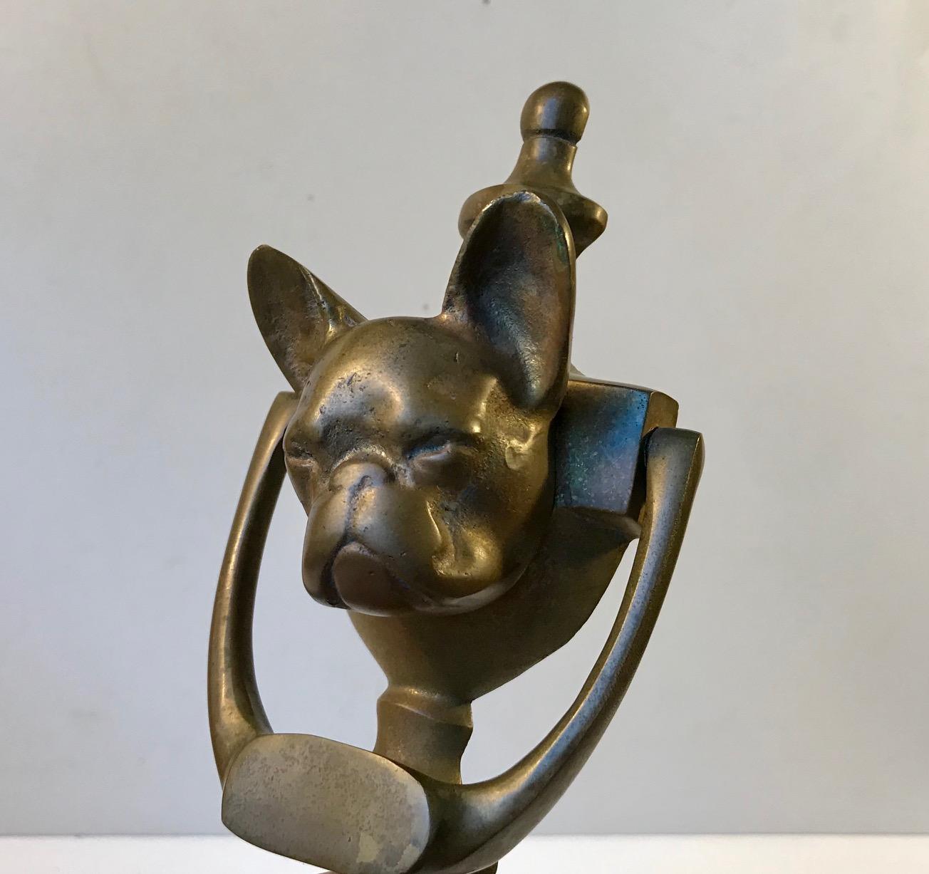 Unusual bronze door knocker with a French bulldog head as a center decoration. The bronze has aged and patinated beautifully. It was made in Germany or France during the 1950s and it works like a charm.