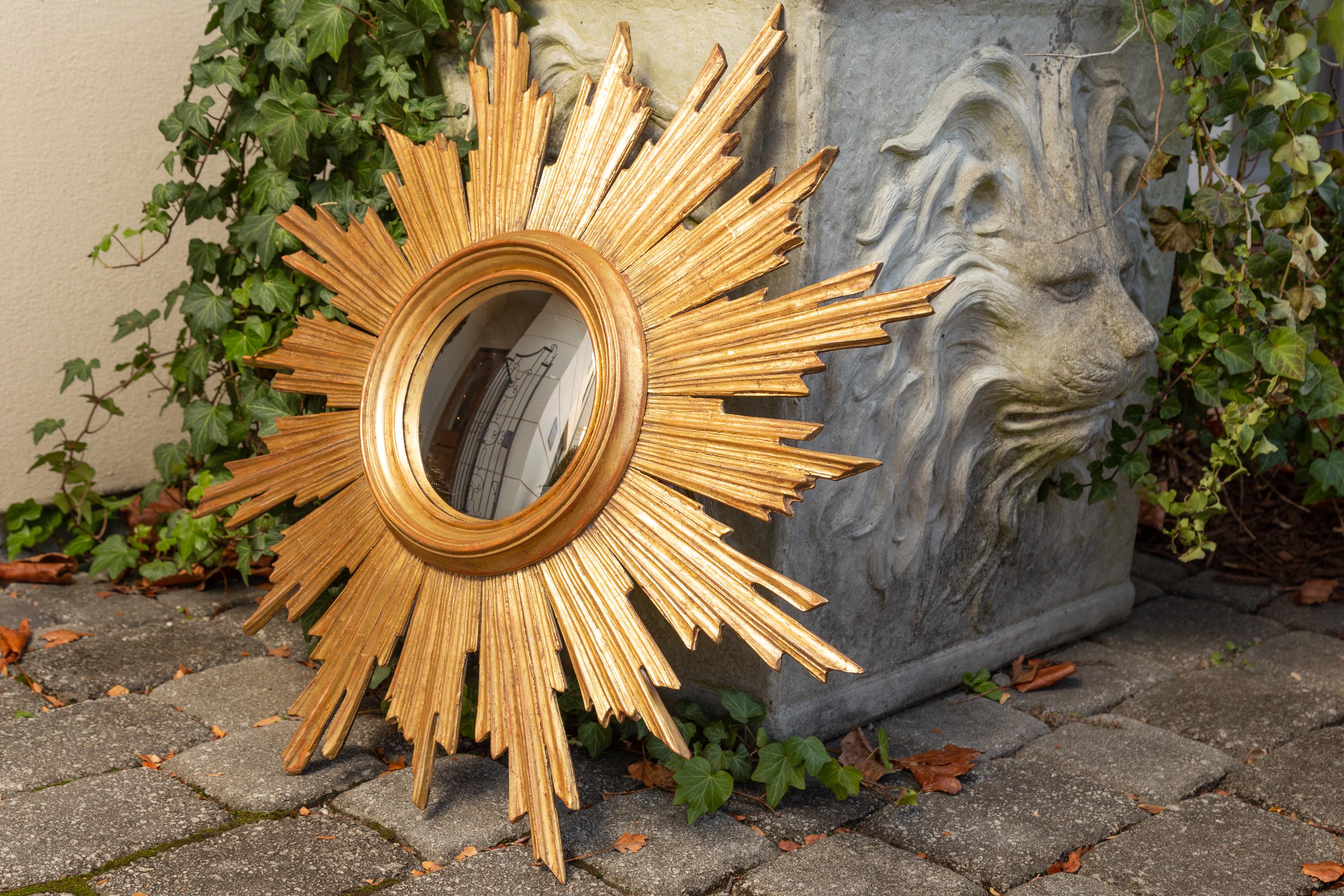 A vintage French giltwood sunburst with convex mirror plate from the mid-20th century. Born in France during the midcentury period, this medium size giltwood sunburst features a central convex mirror plate, surrounded by a molded inner frame. Our