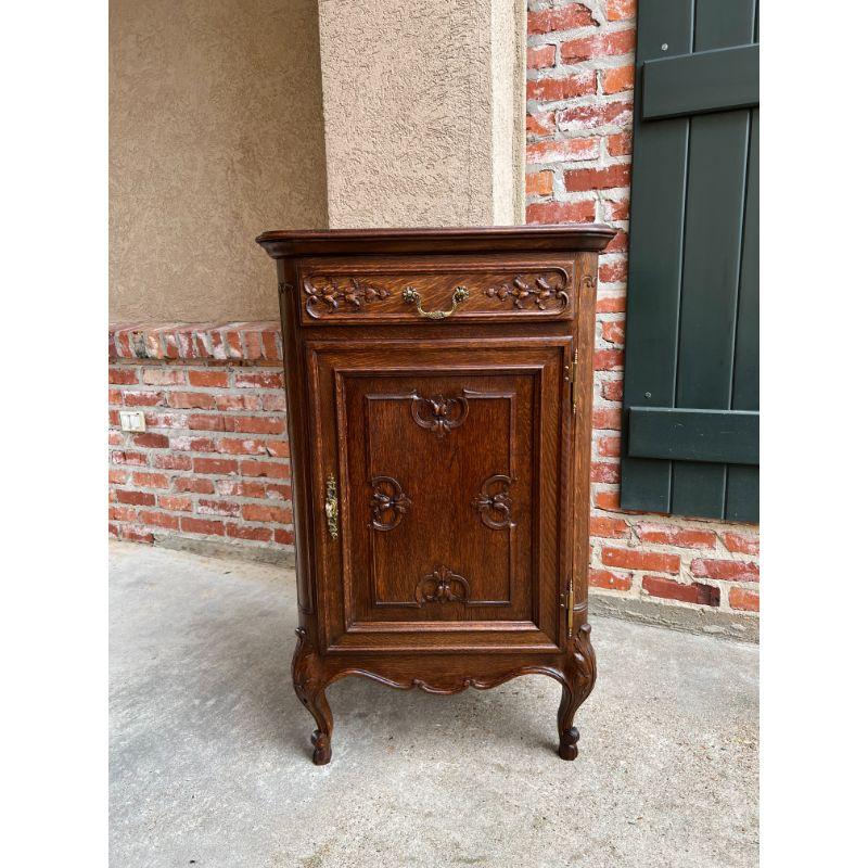 Vintage French Carved Oak Cabinet Display Stand Louis XV Style.

Direct from France, a charming vintage French Louis XV style cabinet!
Carved front drawer with brass pull over the large door with recessed panel, carved floral design, and original