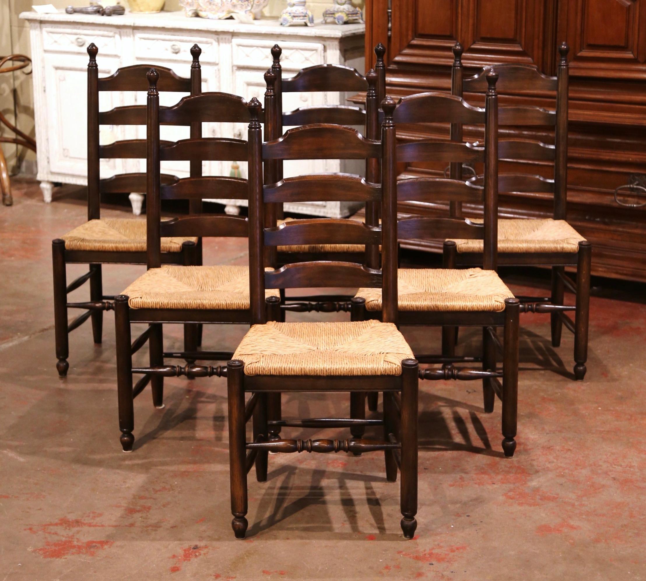These elegant six country chairs were crafted in France, circa 1990. Carved from solid oak, each chair has a tall pitched back for ultimate comfort, and decorated with four ladders across and embellished with decorative finials at the top. The seats