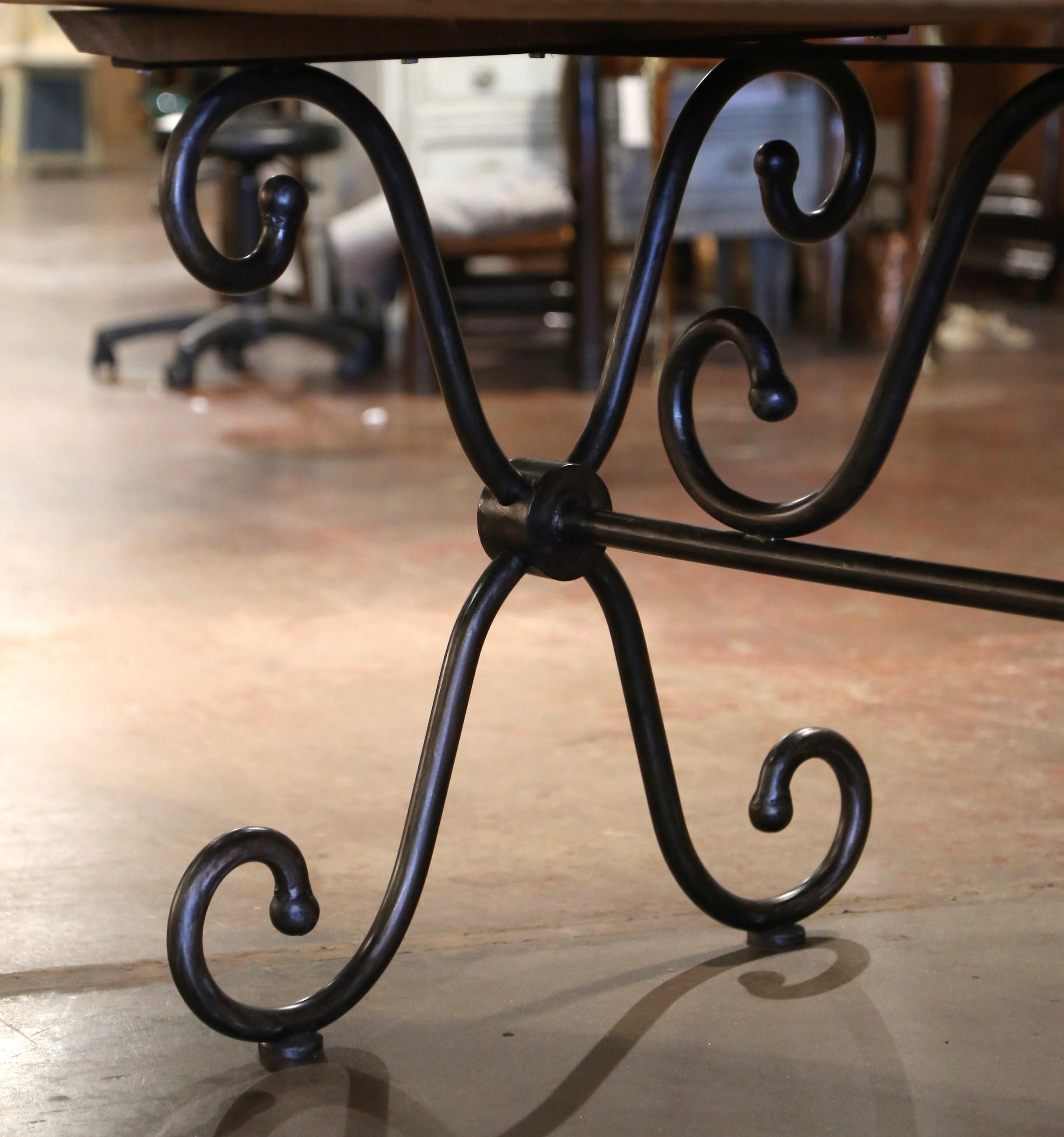 20ième siècle Table de salle à manger ovale française sculptée en pin sur base en fer poli en vente