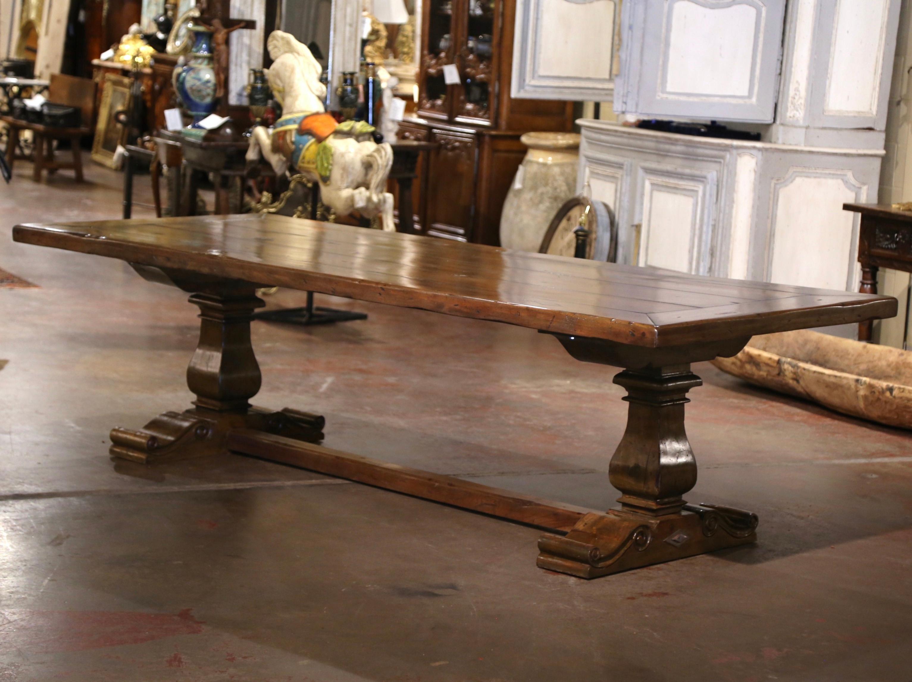 Esta gran mesa de comedor antigua de 9 pies de largo se fabricó en el suroeste de Francia. Construida con maderas antiguas y recuperadas de nogal, la pesada mesa, extremadamente auténtica, se alza sobre una elegante base de caballete, apoyada en
