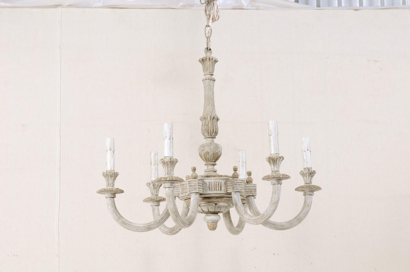 A French carved and painted wood six-light vintage chandelier. This lovely French chandelier from the mid 20th century features a carved central column with diagonal twists and leaf motif wraps, carved lower gallery, and bottom acorn finial. Six
