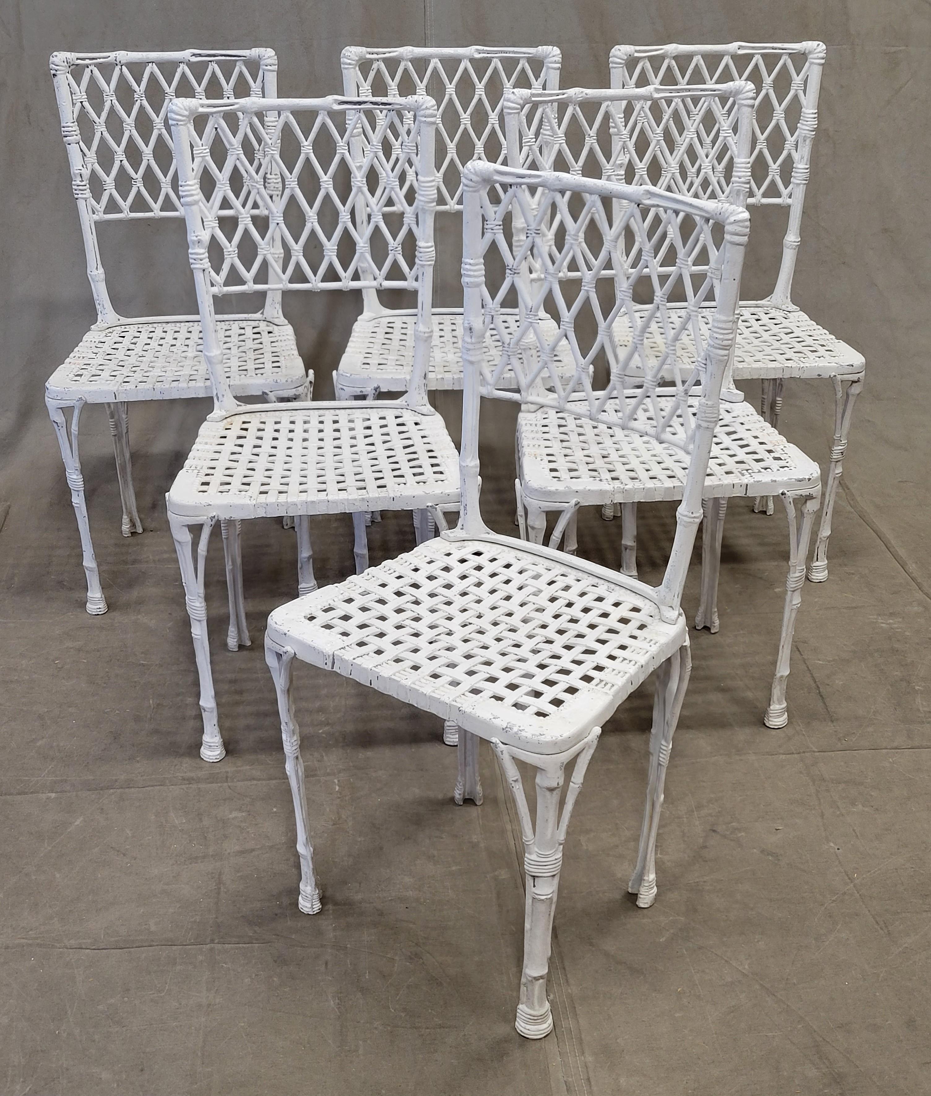 An absolutely charming set of six solid cast vintage French aluminum chinoiserie faux bamboo garden chairs. Old white paint that is worn adds to the charm of this set. They are strong and ready for many years of use on your patio or in your