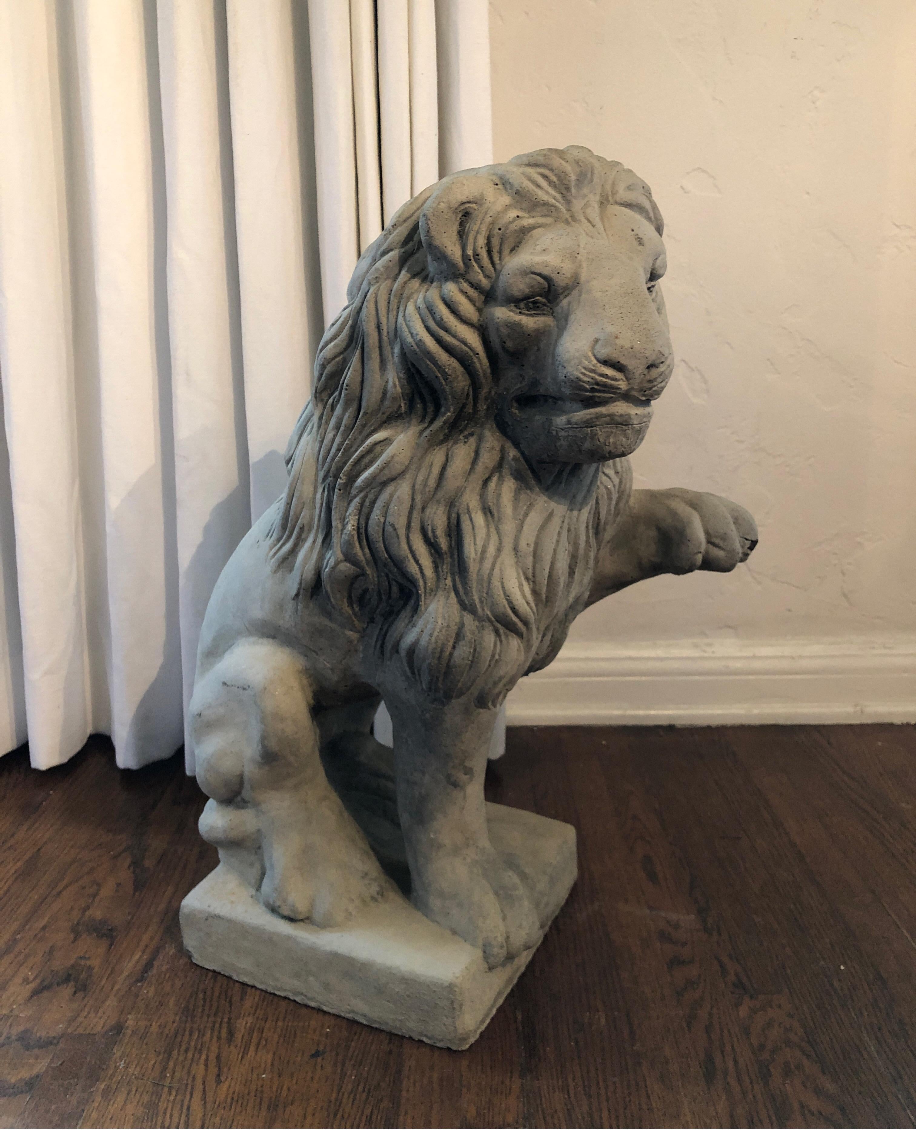 Mid-20th century cast stone garden sculpture lion seated on plinth with one paw raised. Beautiful detail of head and mane. Some natural patina and works great for interior or exterior.
Please note, one crack/chip on one paw. See pics. 

            