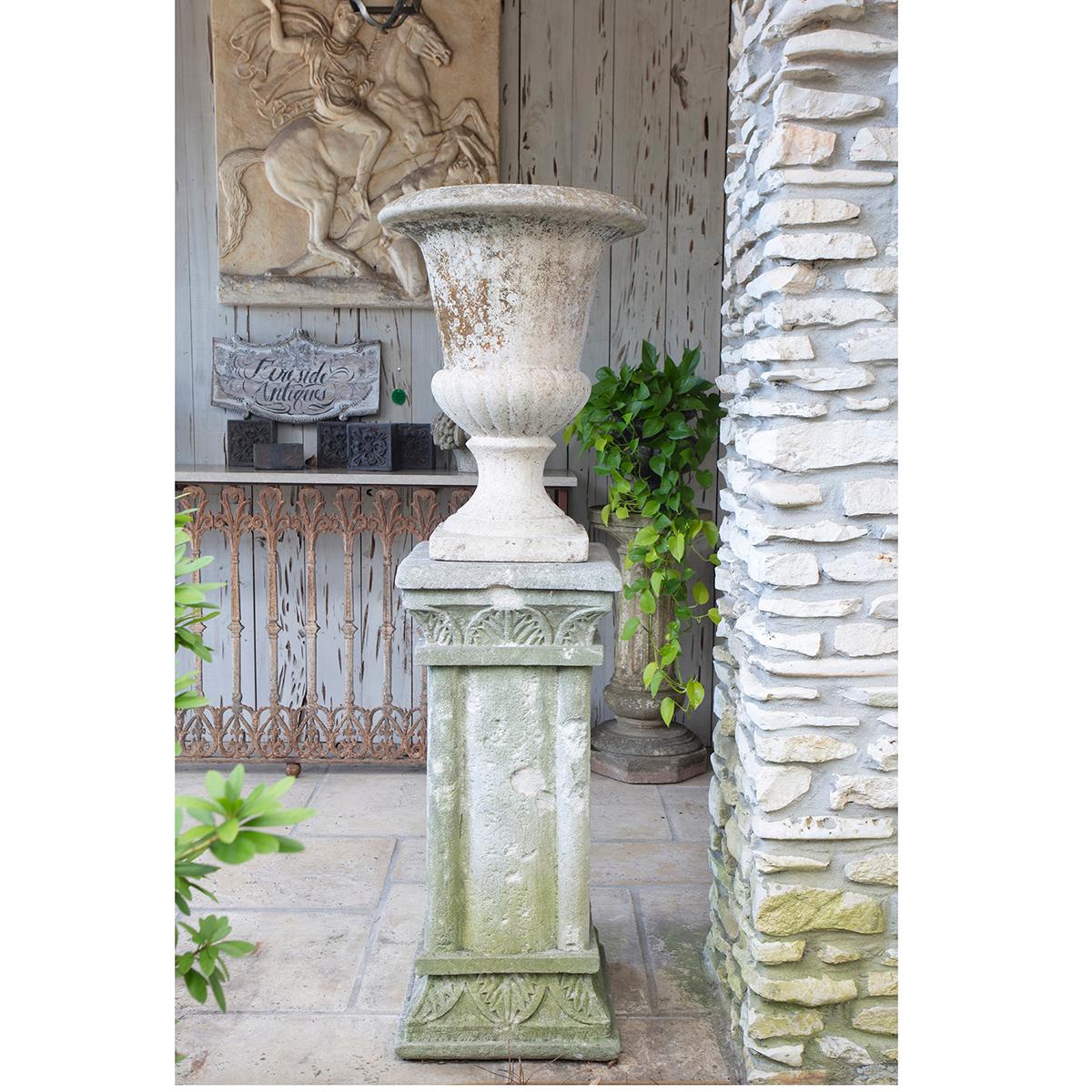 Beautifully weathered French cast stone urn and pedestal. Both pieces have an earthy patina, with moss on the square columnar pedestal. They will add character to any garden or landscape. Urn dimensions: 26” height x 20” diameter. Pedestal