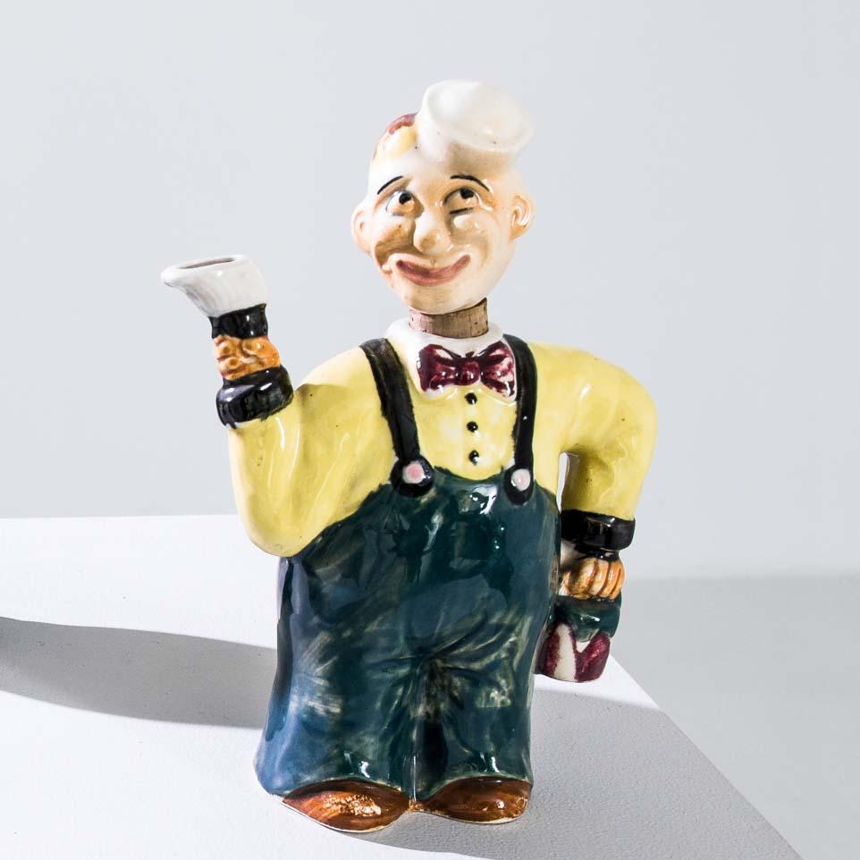 An assortment of glazed ceramic bottles in the shape of drinking men. Made in France between 1950 and 1960, the bottles depict people of various nationalities raising a toast with their typical tipple. The heads of the figurines double as corks; the