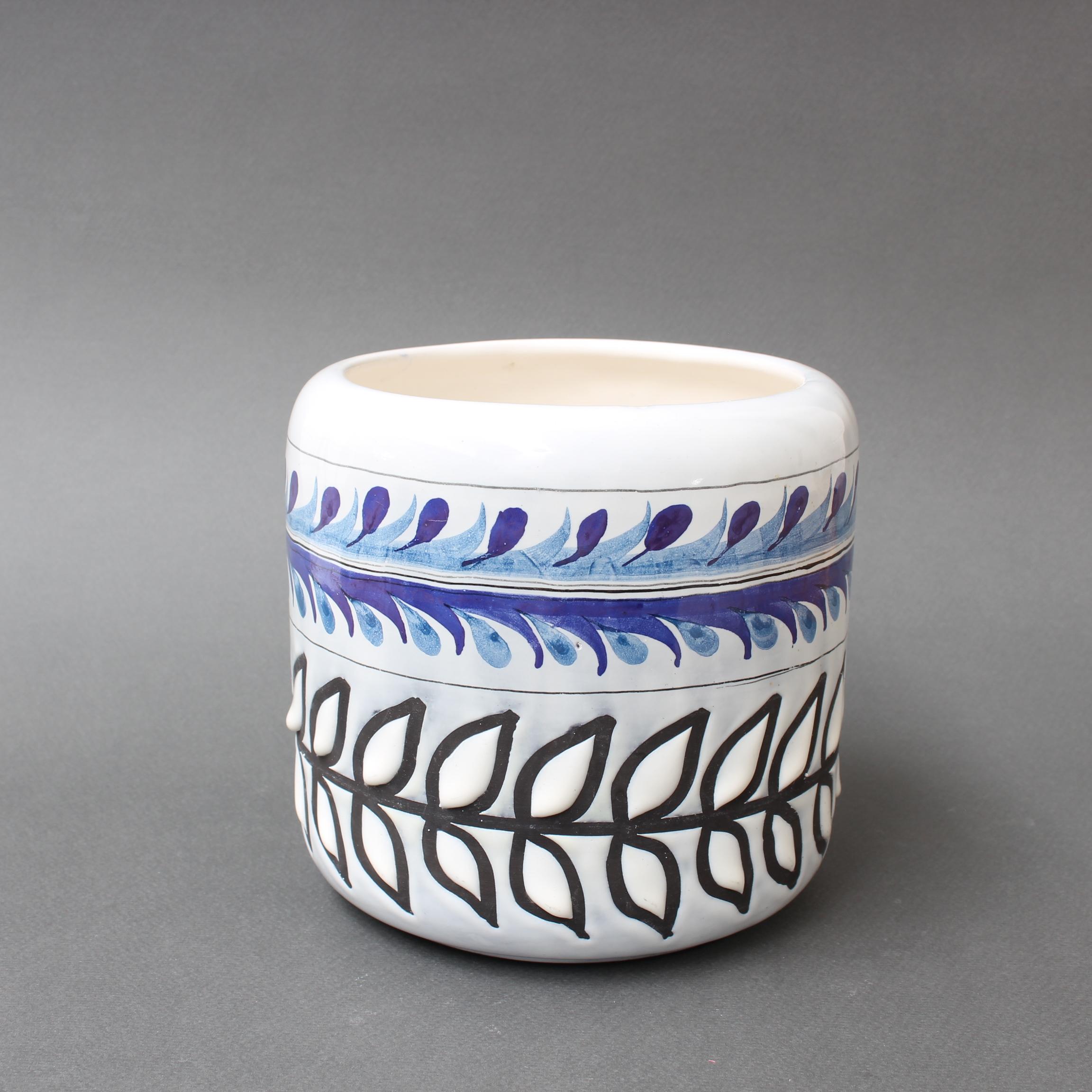 Vintage French ceramic cachepôt by Roger Capron (circa 1960s). A luscious creamy white base with a top band in a repeating pattern in lovely blues; below that another with leaf motif contrasts in black and white. The white of the leaves consist of