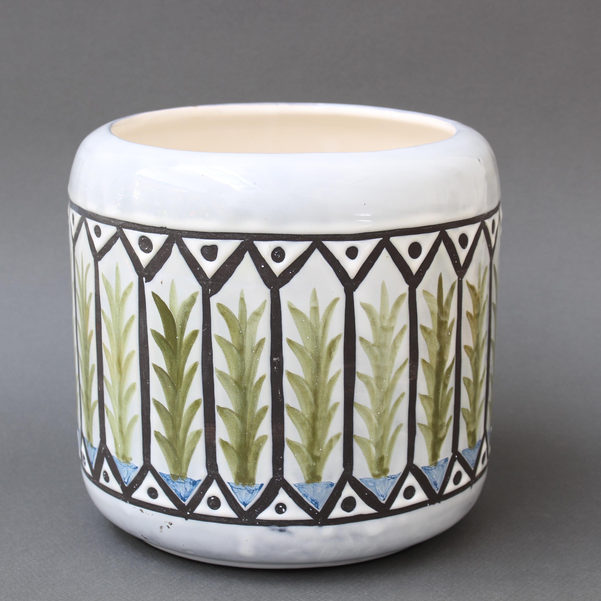 Vintage French ceramic cachepot by Roger Capron (circa 1970s). A charming Provençal style cover pot presents a surrounding band with repeating plant motif and geometric shapes. There is a hint of blue above and below the decorative band. The pot is