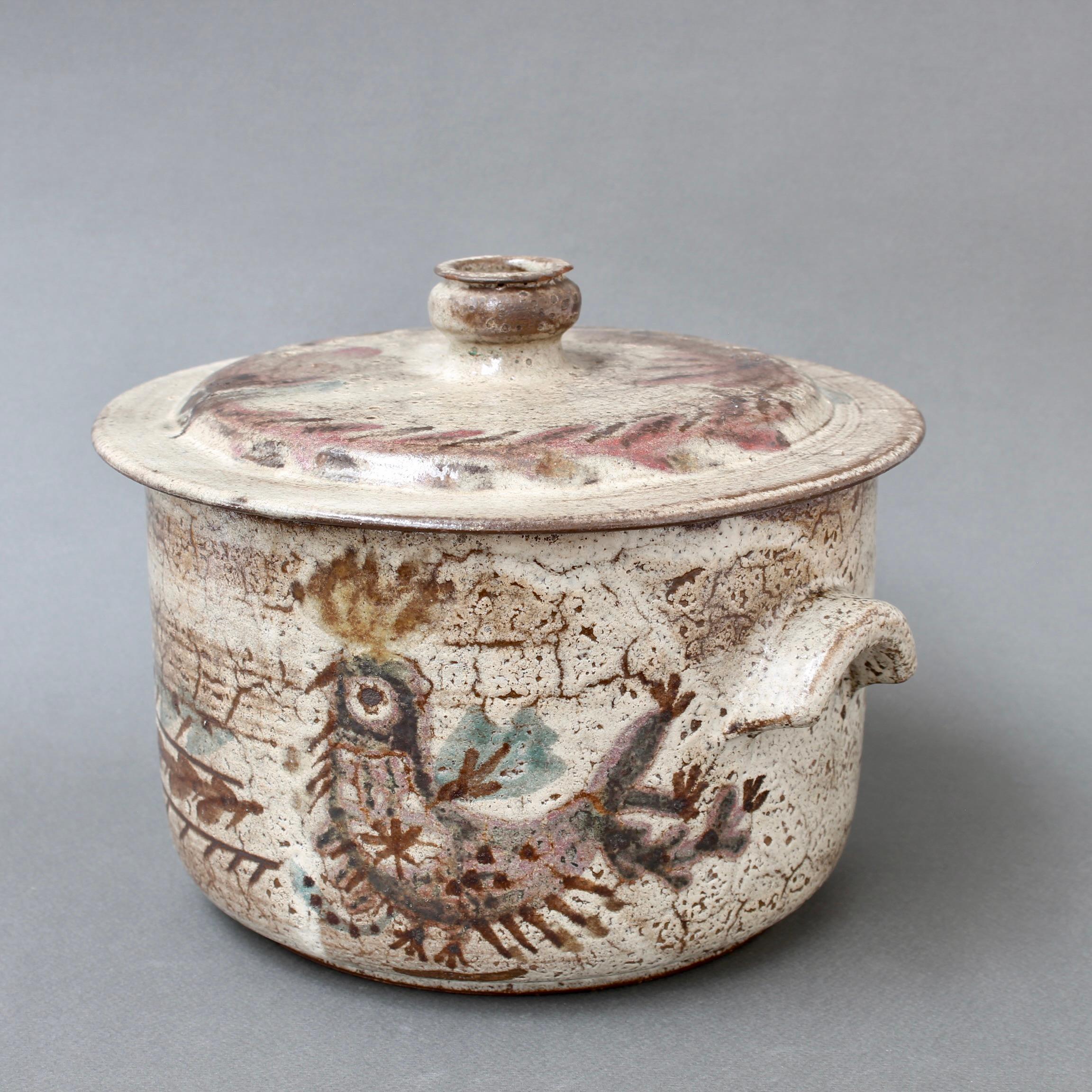 Decorative vintage ceramic casserole with lid by Gustave Reynaud, Le Mûrier (circa 1950s). On the rustic exterior is a characteristically French rooster in a light mulberry colour with blue-green highlights. Alongside is a series of leaves on a