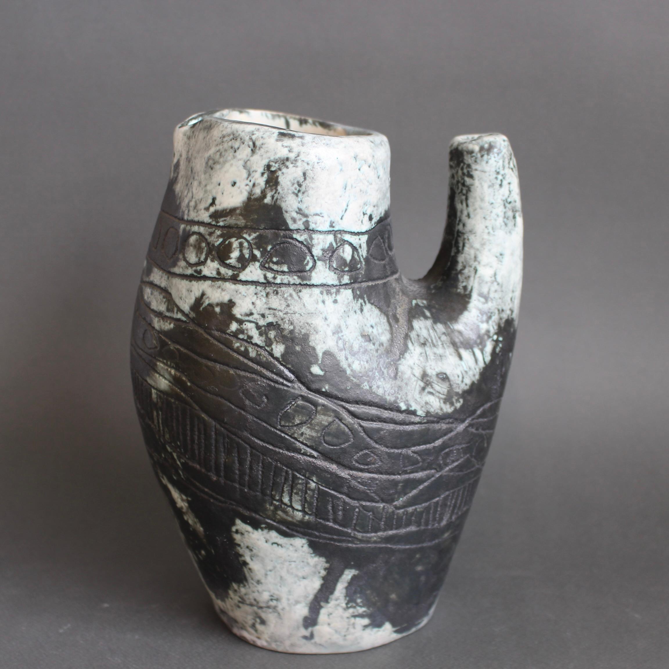 Brocca / vaso in ceramica francese d'epoca (circa anni '50) di Jacques Blin. La brocca, che forse ha la forma di un fiero coq francese o di un gufo, è di una sottile tonalità verdastra, quasi marmorea, ricoperta dallo smalto nebbioso tipico di Blin.