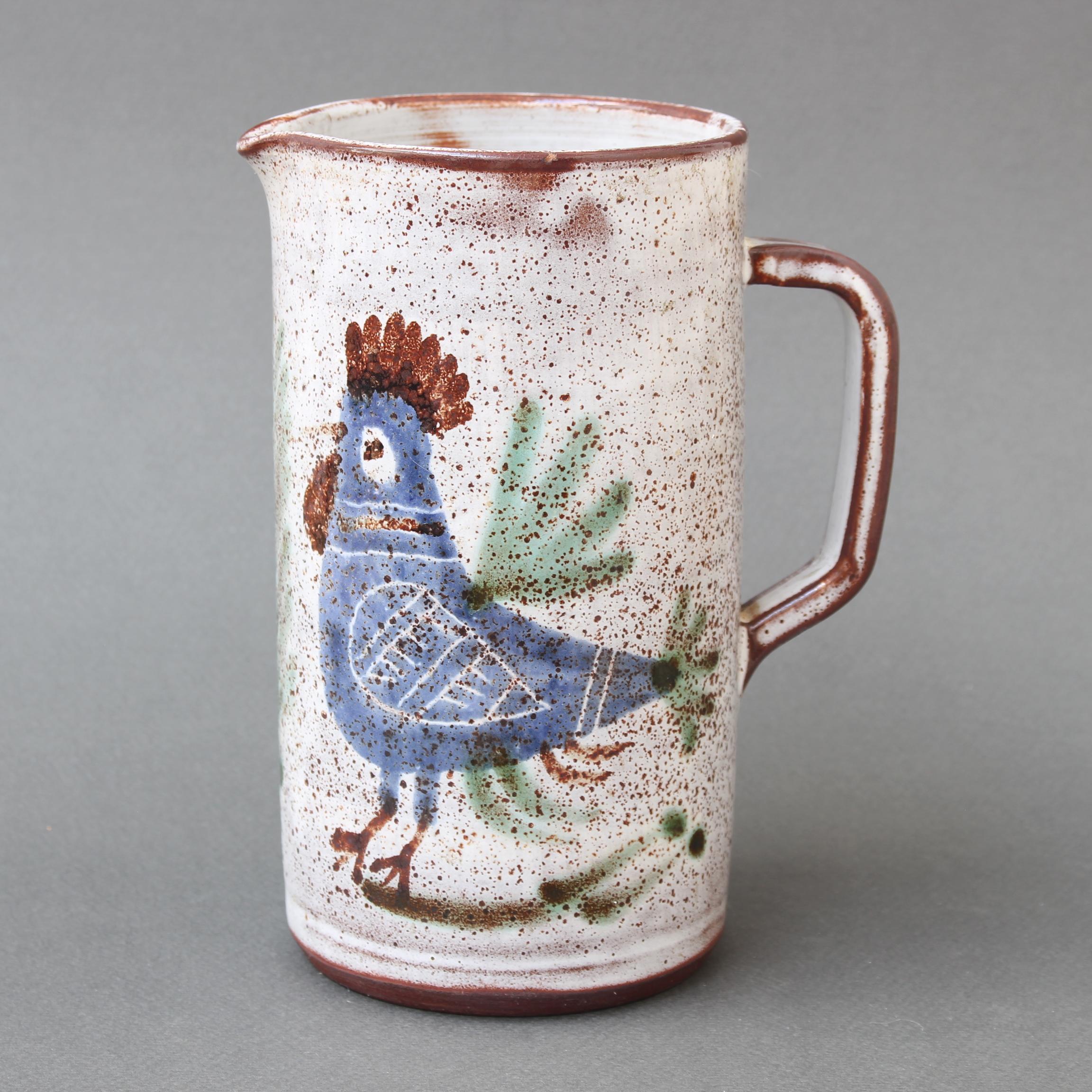 Vintage French ceramic small pitcher by Michel Barbier (circa 1960s). A charming, rustic ceramic pitcher with ear-shaped handle and a small spout on the lip. A creamy white glaze with mottled reddish-brown patches form the base of the piece that