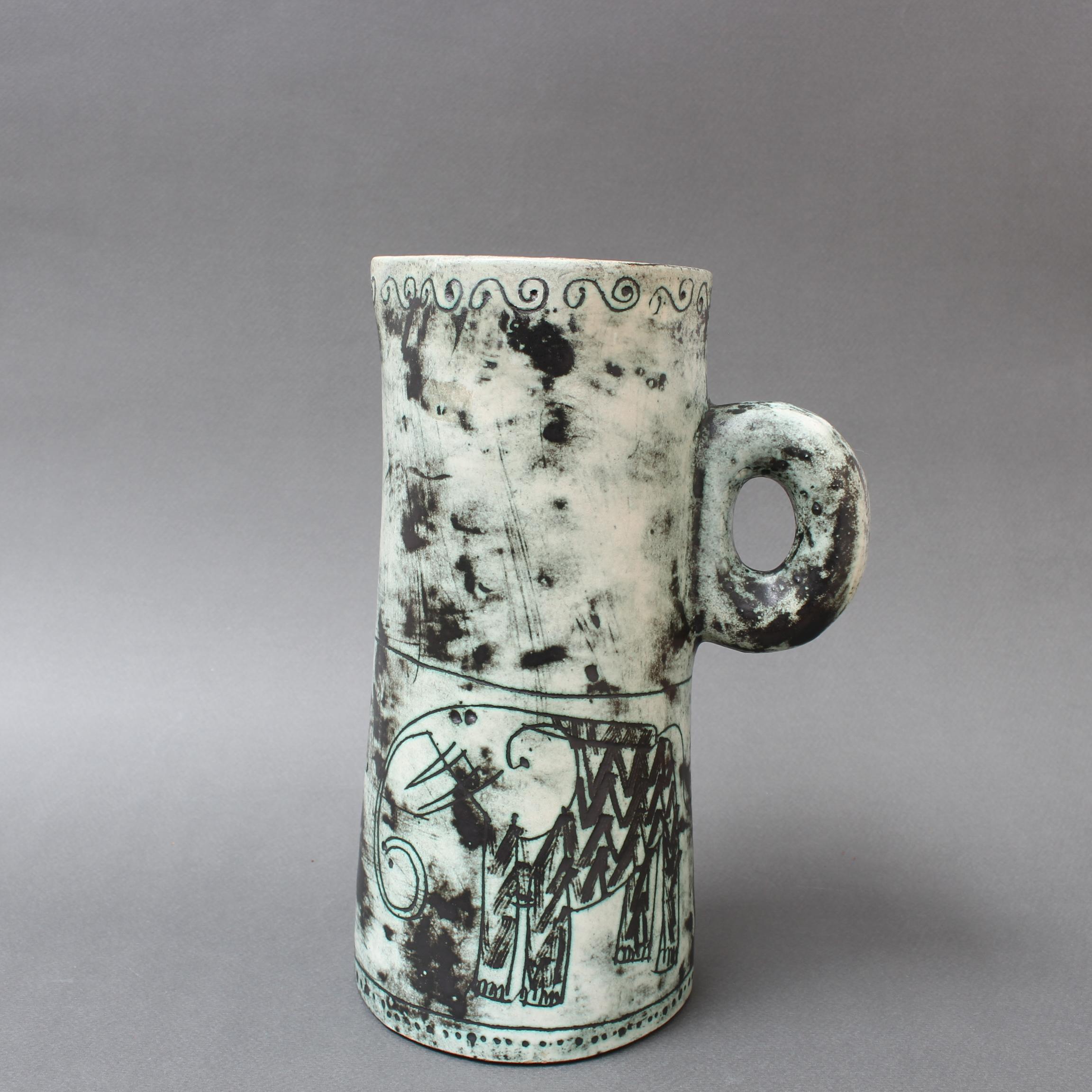 Vintage French ceramic pitcher / vase by Jacques Blin (circa 1950s). This elegant piece has Blin's trademark cloudy glaze and decoration featuring whimsical elephants and plants. The pitcher is visually divided in two by an irregular line encircling