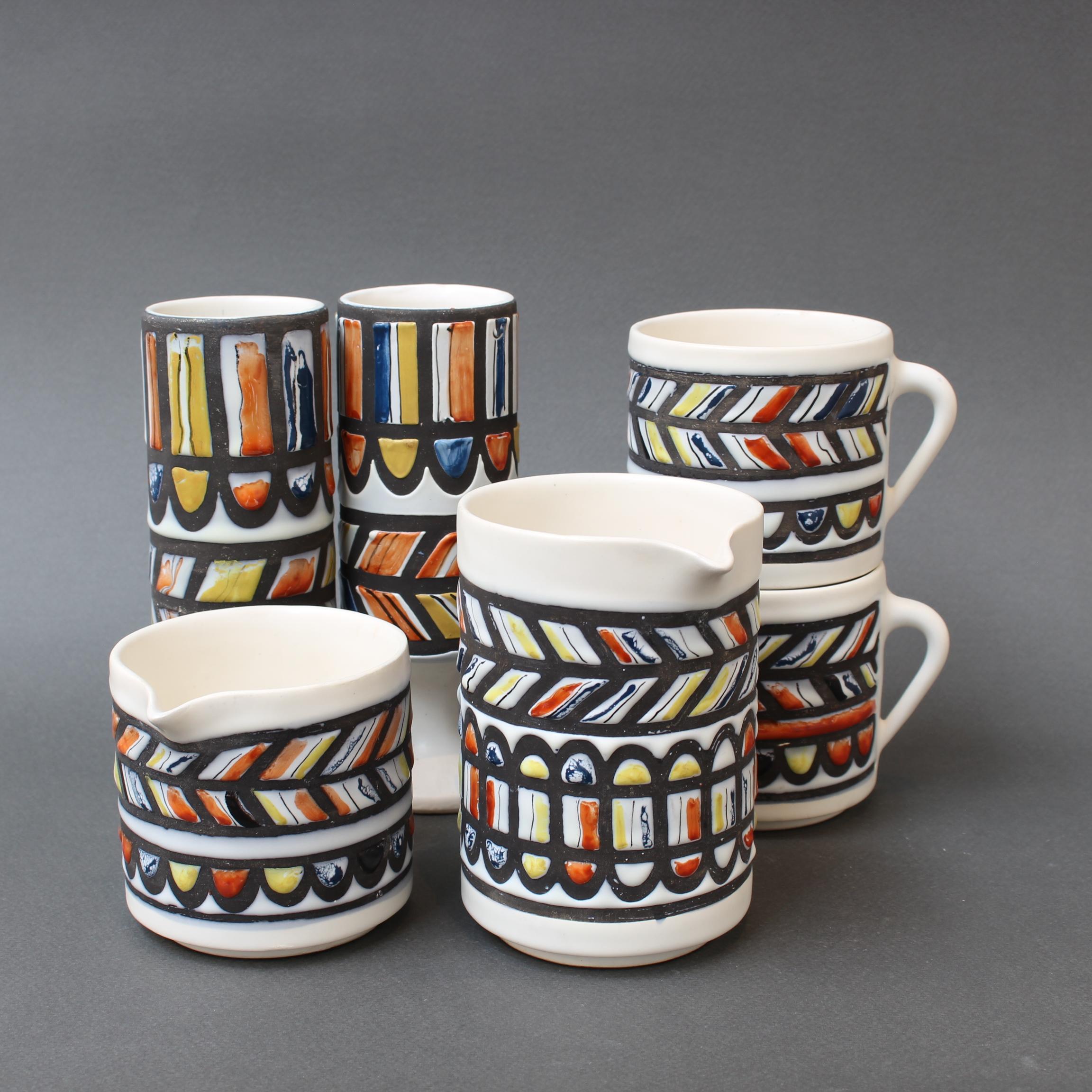 A Mid-Century French ceramic set consisting of a milk jug, a creamer, two cups and two stemmed 'glasses' by master ceramicist, Roger Capron (circa 1960s). Signed under the base with model number (the stemmed glasses have model number only). This