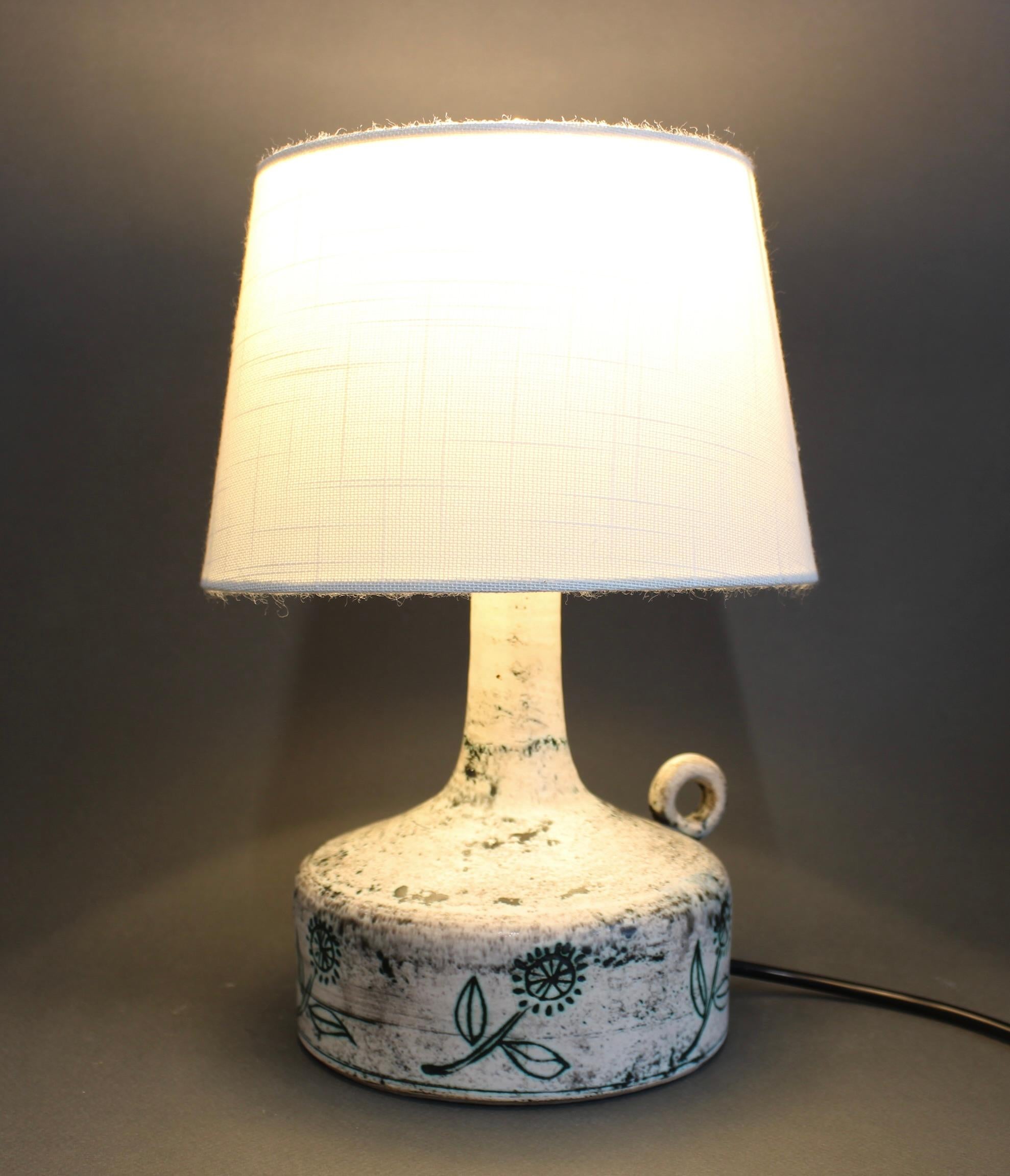 Lámpara de sobremesa francesa vintage de cerámica de Jacques Blin (hacia la década de 1950). Esta lámpara tiene el esmalte turbio característico de Blin, con un toque rosa salmón y grabados de flores de fantasía. Su forma elegante se complementa con