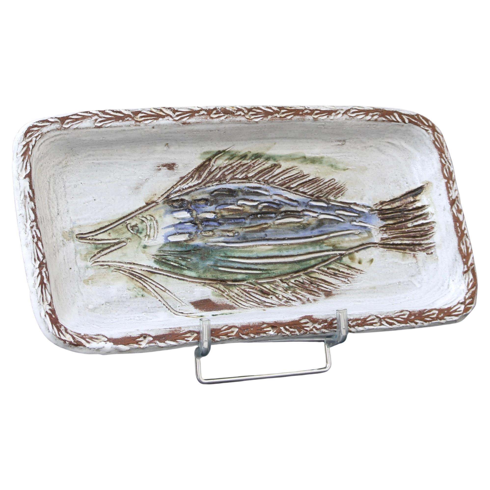 French ceramic decorative dish with fish motif (circa 1970s) by Albert Thiry. A rectangular-shaped ceramic dish has rounded edges with a chalk-white glaze surface. Within the dish's recess a fish is incised into the glaze and painted in Thiry's