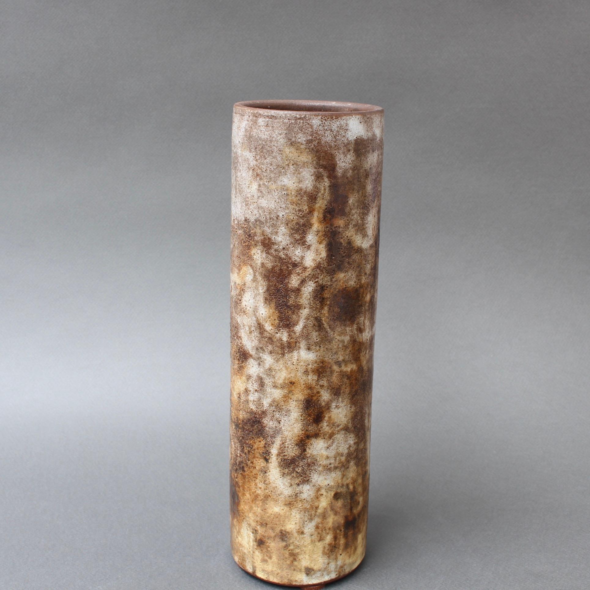 Vaso in ceramica francese di Alexandre Kostanda, (circa anni '60). Questo bellissimo vaso cilindrico presenta un aspetto nebbioso con toni naturali della terra in marrone, beige e delicati accenni di giallo. Oltre a essere visivamente stupefacente,