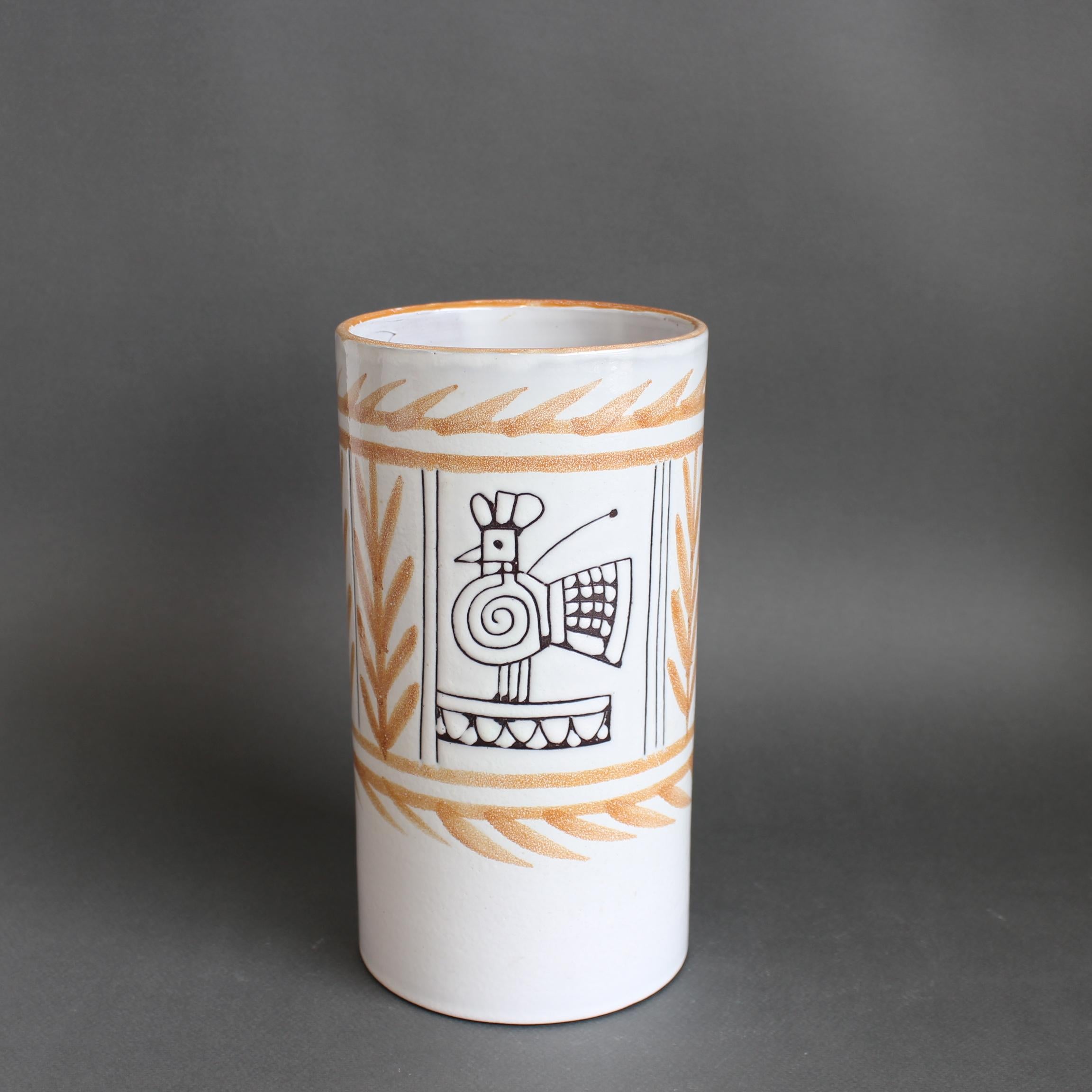 Vaso in ceramica della metà del secolo scorso (circa 1960) di A. Michel Barbier. Un elegante vaso cilindrico con un gallo francese stilizzato e un motivo vegetale su uno smalto bianco crema ed elegantemente lucido che avvolge il corpo e il labbro.