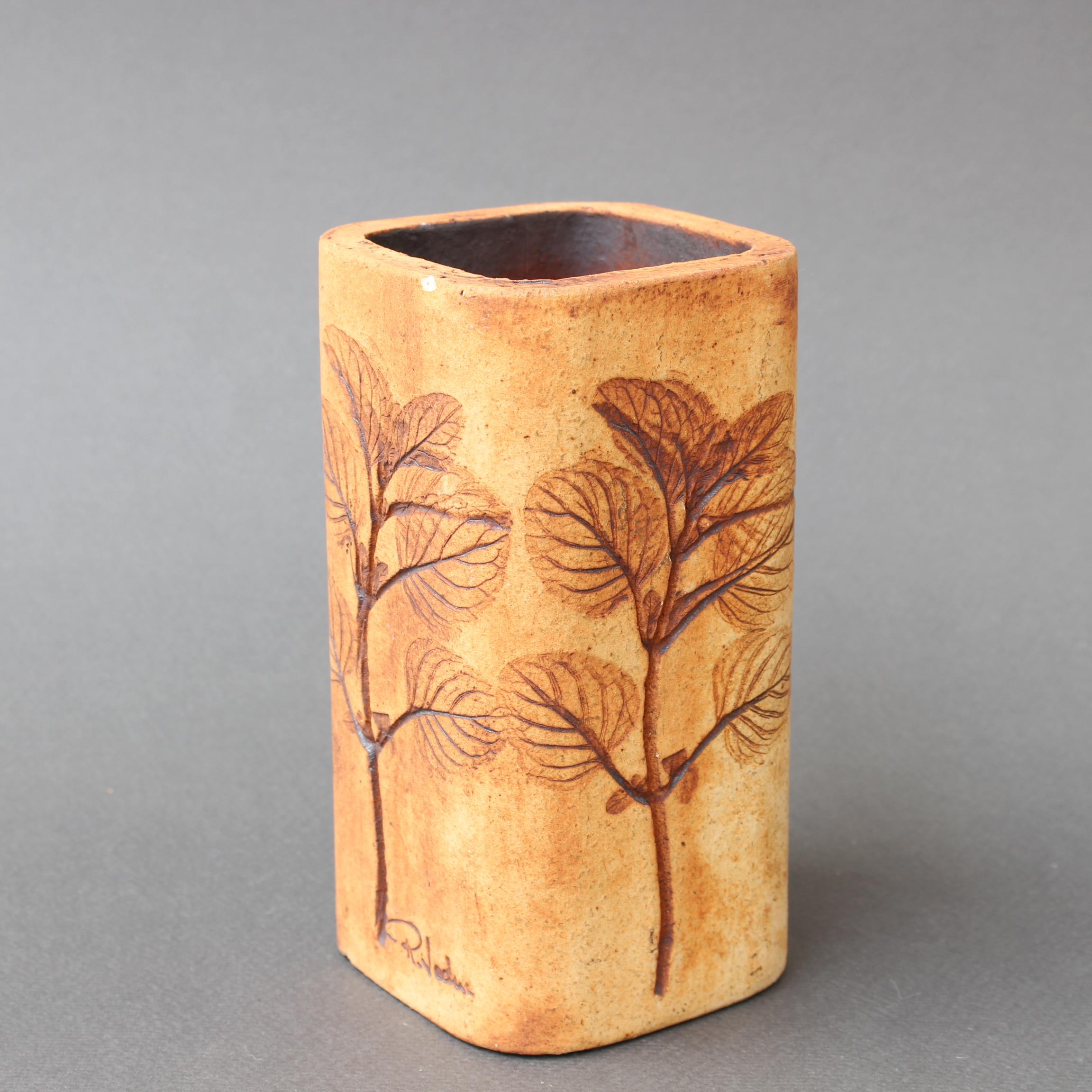 Vintage ceramic vase (or pencil holder if you prefer) by Raymonde Leduc (circa 1970s). Sandstone coloured small vessel with plant motifs inlaid on all four sides. In good overall condition with just a single, very slight visible chip under the lip