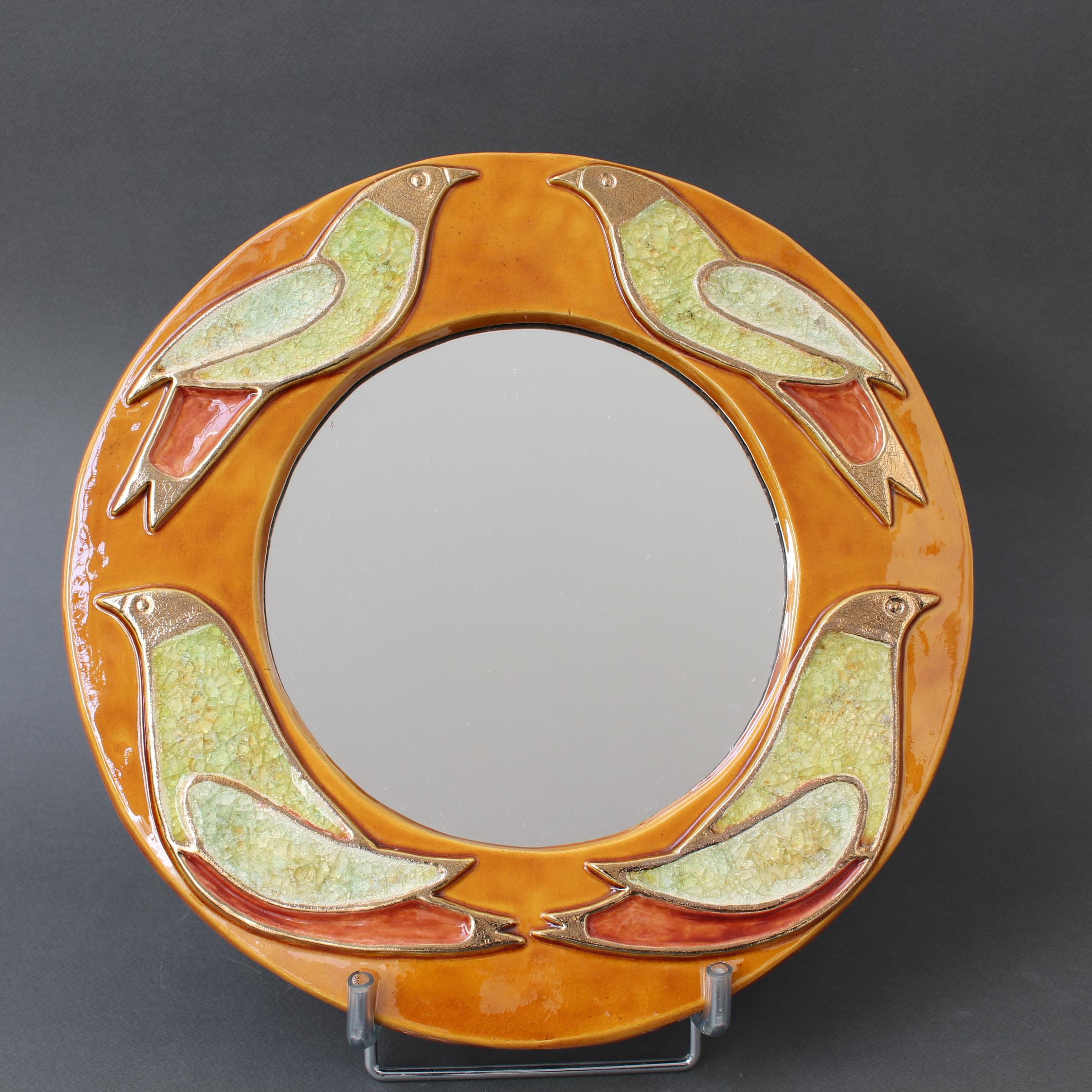 Vintage French ceramic wall mirror with bird motif (circa 1960s), by Mithé Espelt. A porthole-shaped decorative wall mirror delights the eye. The stylised birds are outlined in Espelt's trademark gold craquelure yet their interior gives the