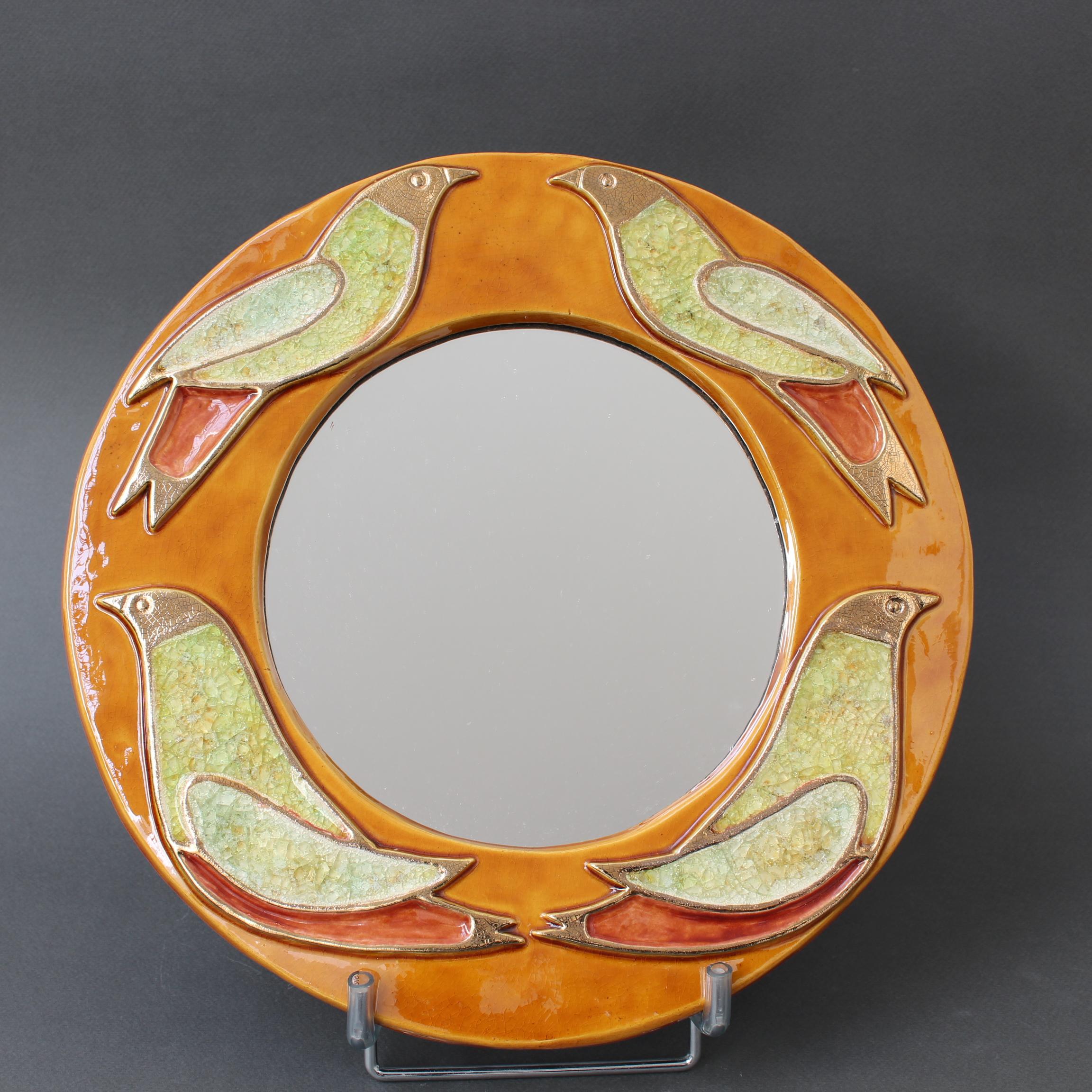 Miroir mural vintage en céramique avec motif d'oiseaux (circa 1960), par Mithé Espelt. Un miroir mural décoratif en forme de hublot ravit l'œil. Les oiseaux stylisés sont entourés de la craquelure dorée caractéristique d'Espelt, mais leur intérieur