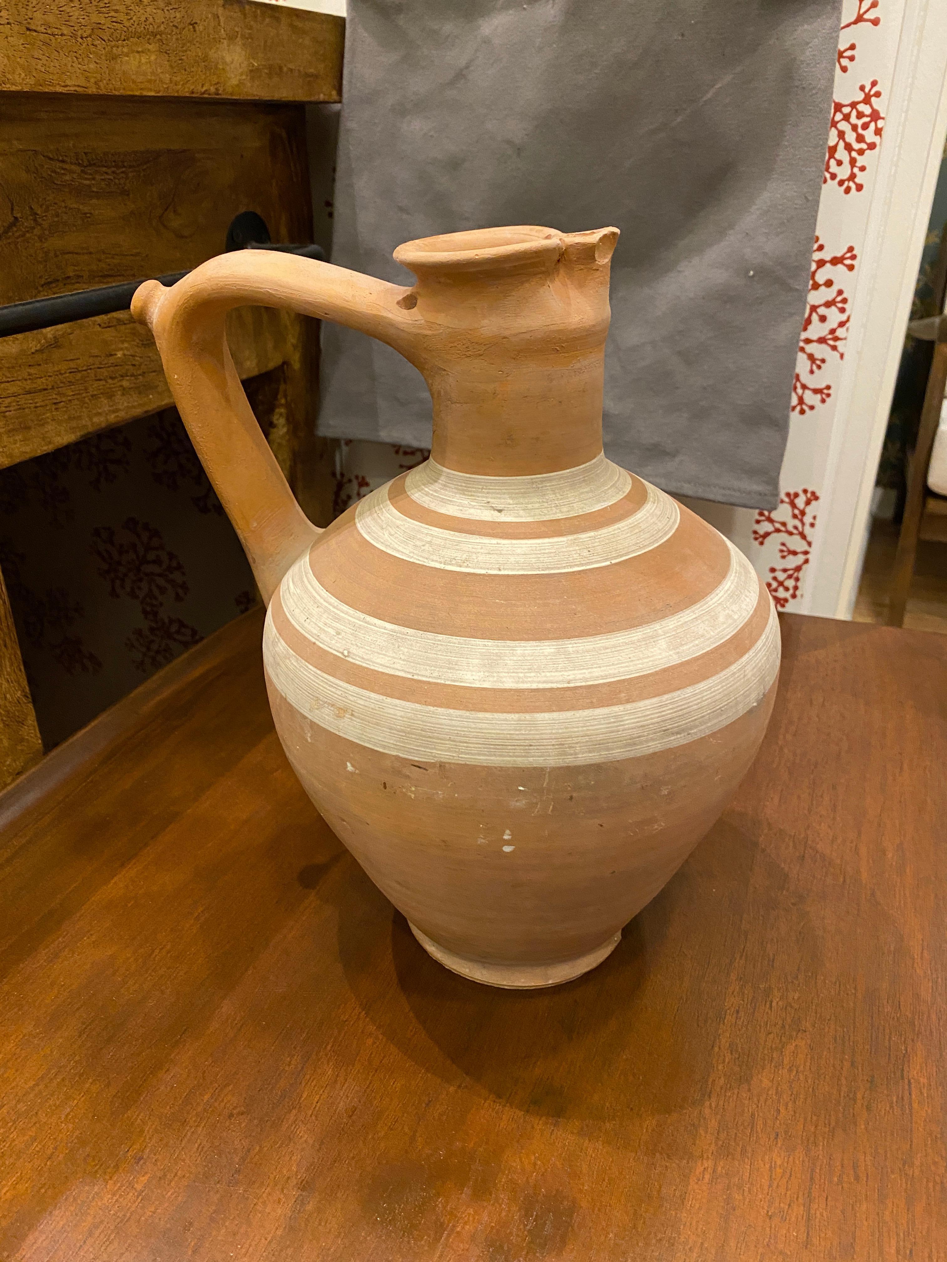 A pristine vintage wine carafe in a beautiful warm terracotta color. A great accent piece for a home looking to add warmth and history to their home decor.