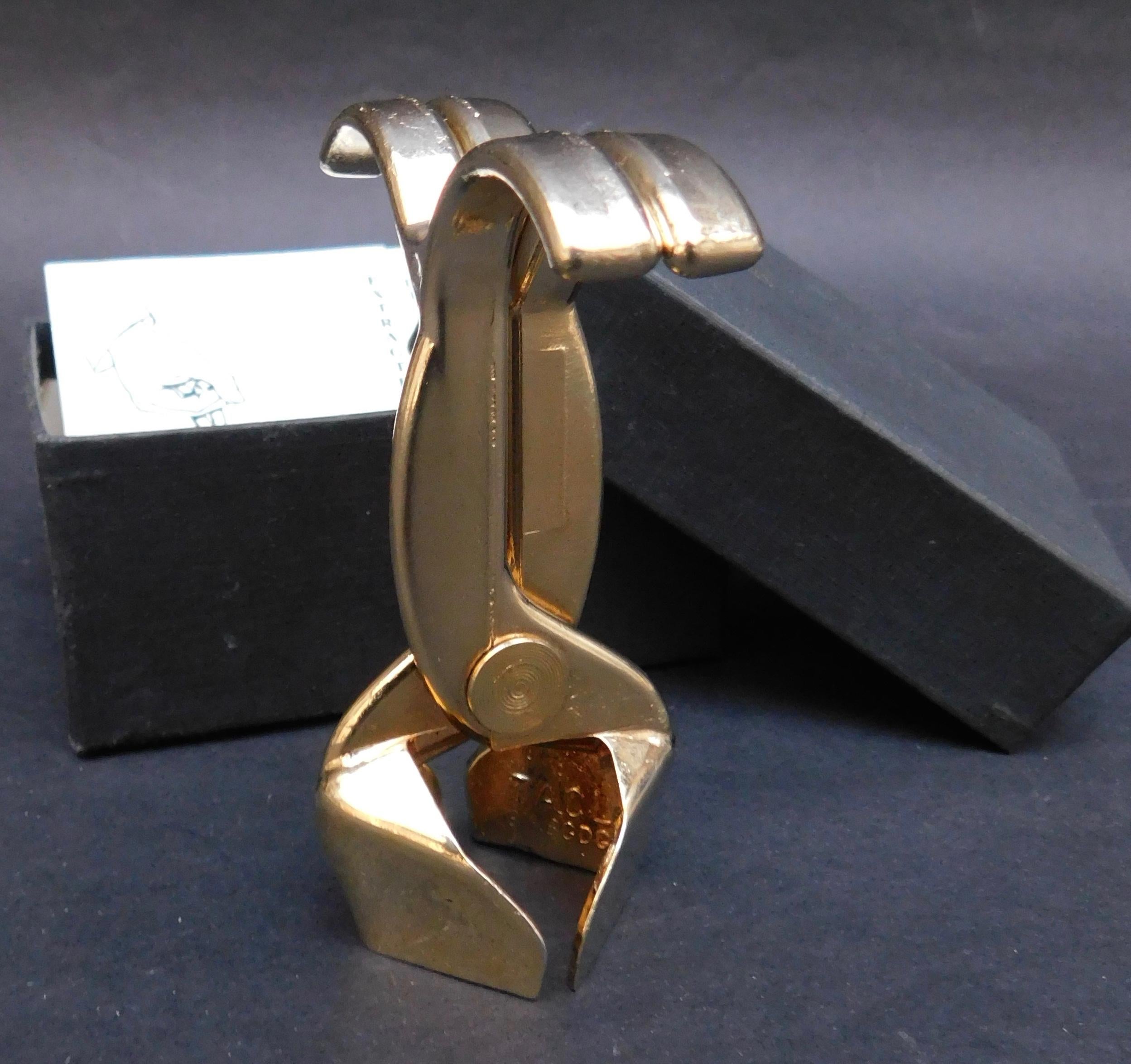 1970s French Champagne bottle opener made by Cado Paris. Used to elegantly grip and pull the champagne cork for a chic presentation every time. 
The perfect gift or bar accessory.
Includes the original box and booklet