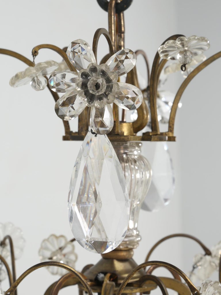 Vintage French Maison Jansen-style bronze and crystal 8-light chandelier, featuring crystal links, pendants, faceted prisms, rosettes and flowers. Re-wired and tested to use immediately.