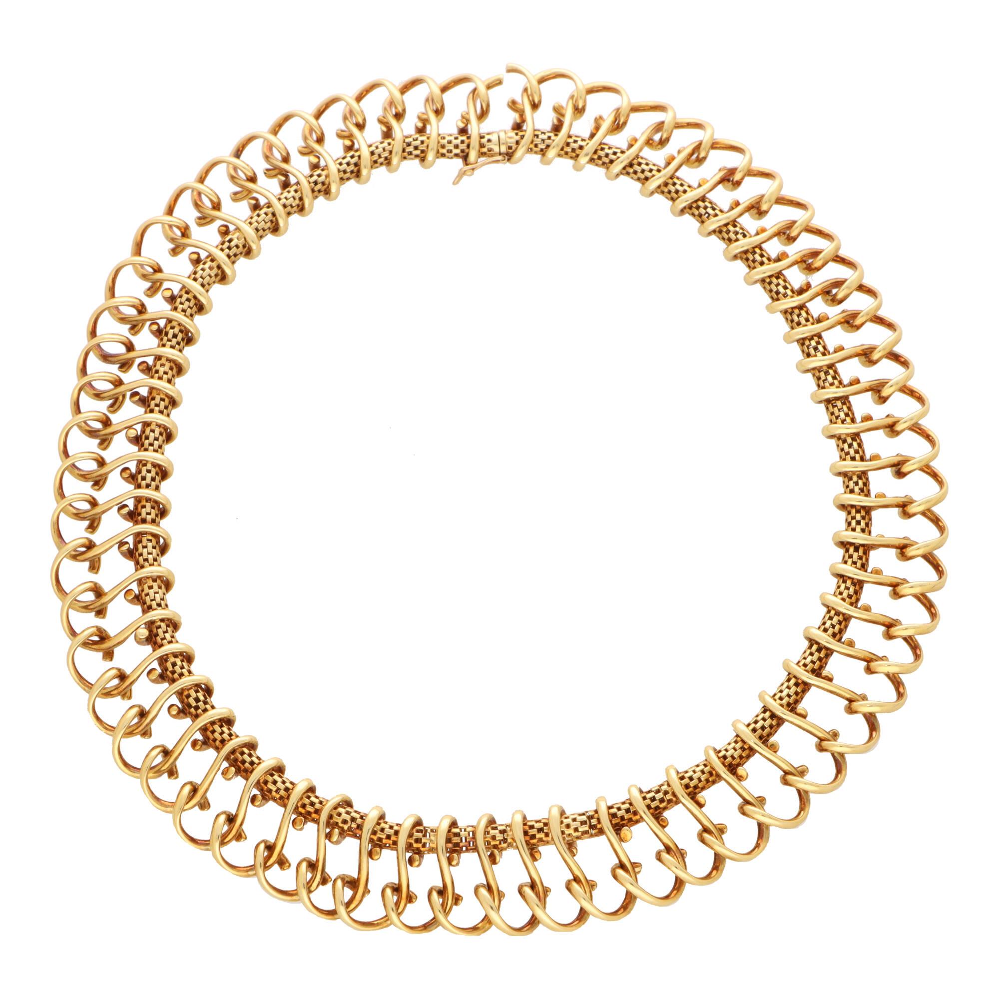 Eine schöne französische Halskette im Vintage-Stil aus 18 Karat Gelbgold.

Die Halskette besteht zunächst aus einem goldenen Maschenseil, das als Basis für das dekorative Design dient. Genau 69 stilisierte Loops aus massivem Gold hängen von der
