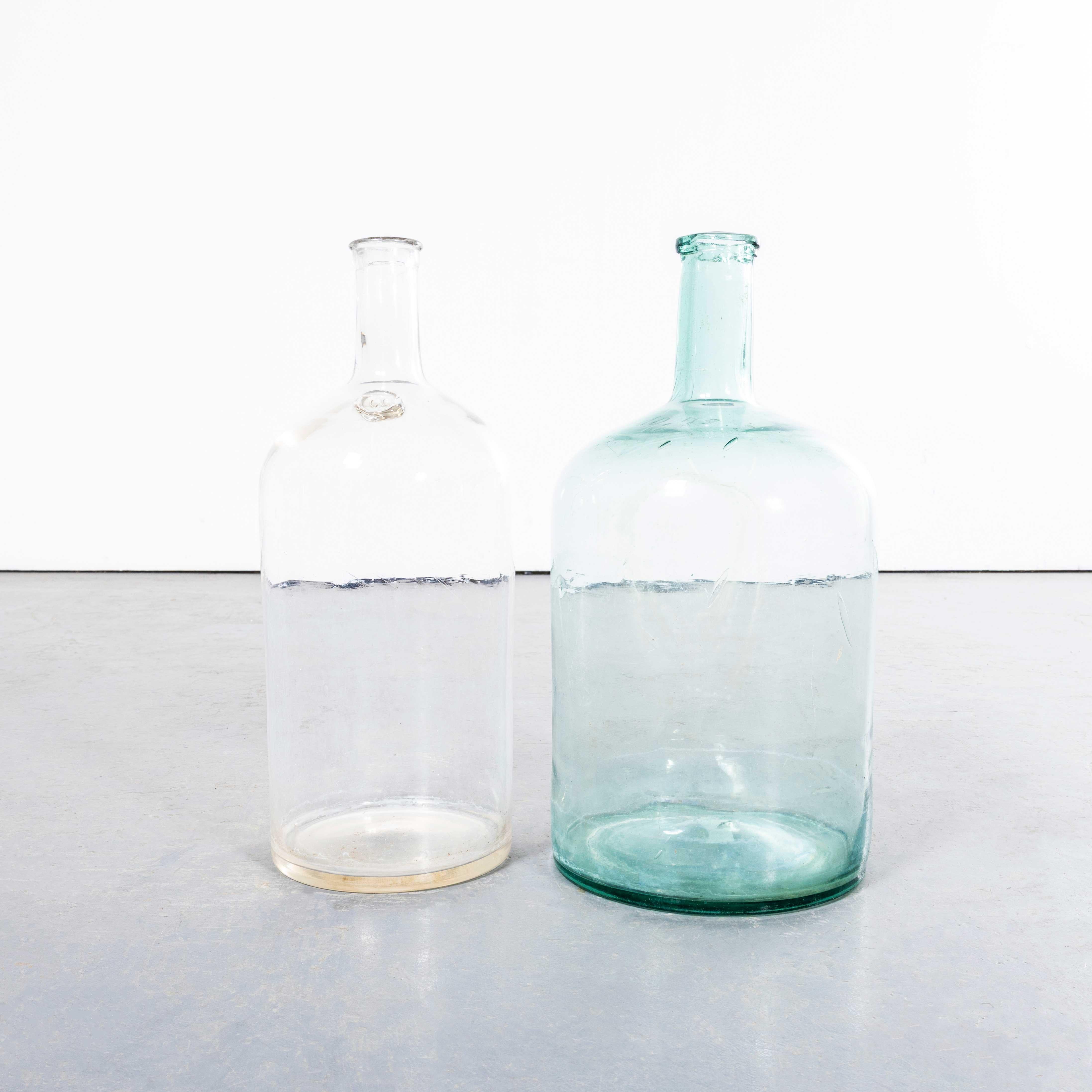 Damigiane francesi d'epoca in vetro trasparente e blu - Coppia. 

Una coppia di damigiane in vetro soffiato a bocca utilizzate come contenitori tradizionali principalmente per la conservazione e il trasporto del vino. Queste damigiane sono state