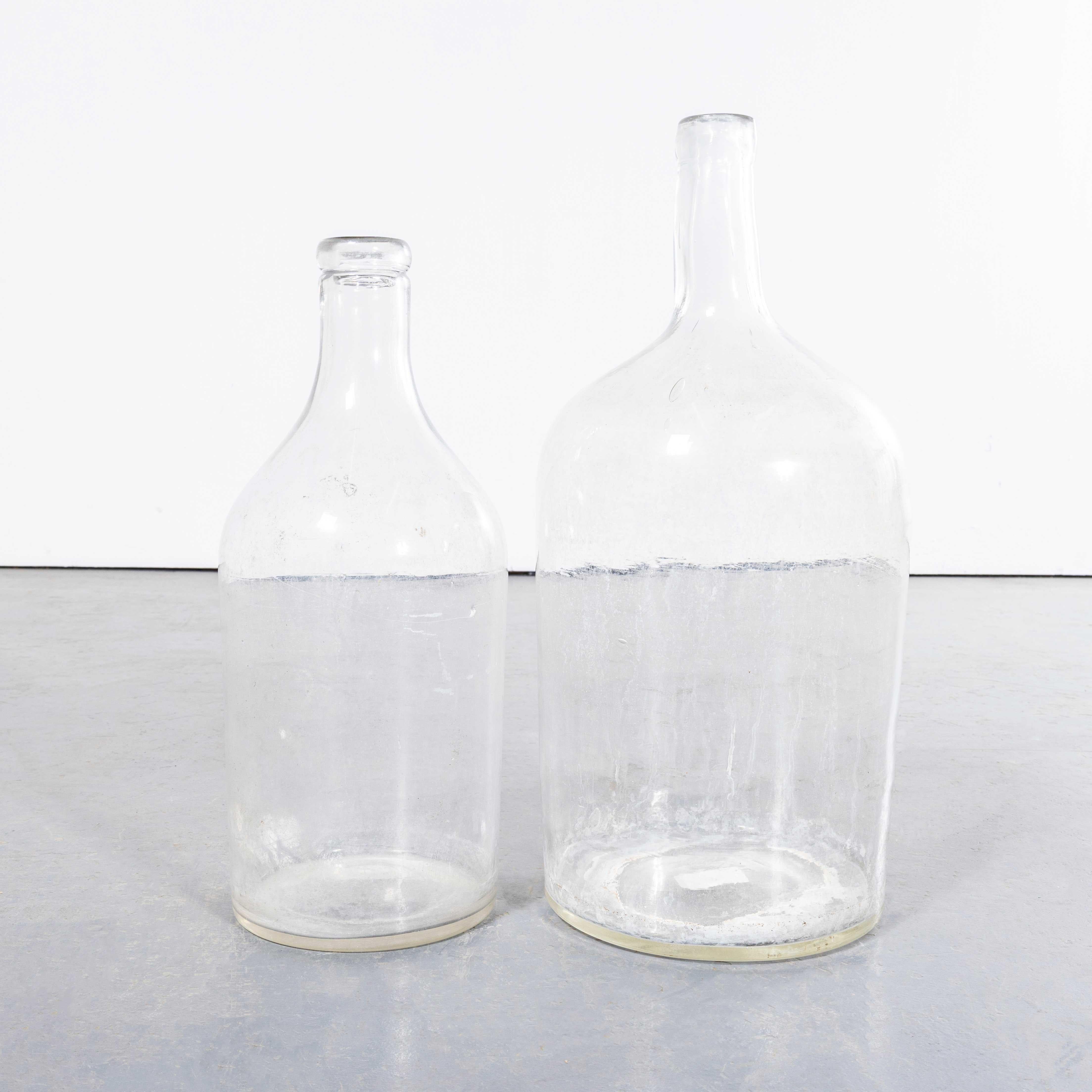 Damigiane di vetro francese vintage - Coppia. Una coppia di damigiane in vetro soffiato a bocca utilizzate come contenitori tradizionali principalmente per la conservazione e il trasporto del vino. Queste damigiane sono state pulite con cura.