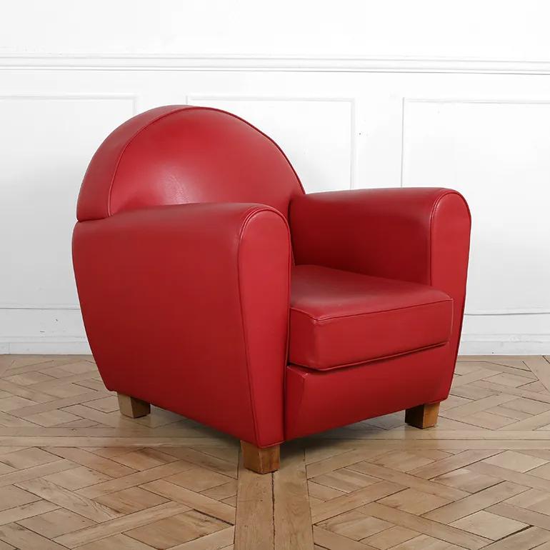 A classic French Art Deco club chair by Hugues Chevalier, upholstered in vibrant red leather, featuring the iconic rounded back, generous arms, and plush cushioning that define the timeless club chair design. Raised on sturdy wood block feet, it