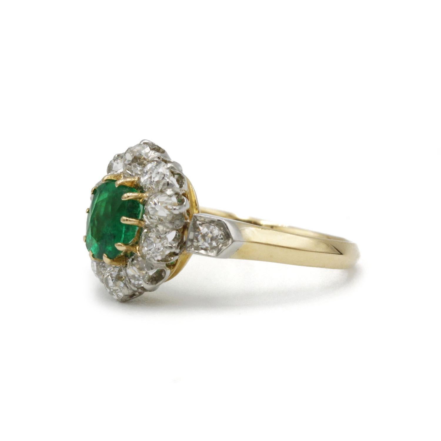 A timeless vintage treasure, this exquisite cluster ring is crafted in a refined combination of 18k yellow gold and platinum. At its heart lies a vivid Colombian emerald, certified by Carat Gem Lab, radiating natural charm and allure. Surrounding