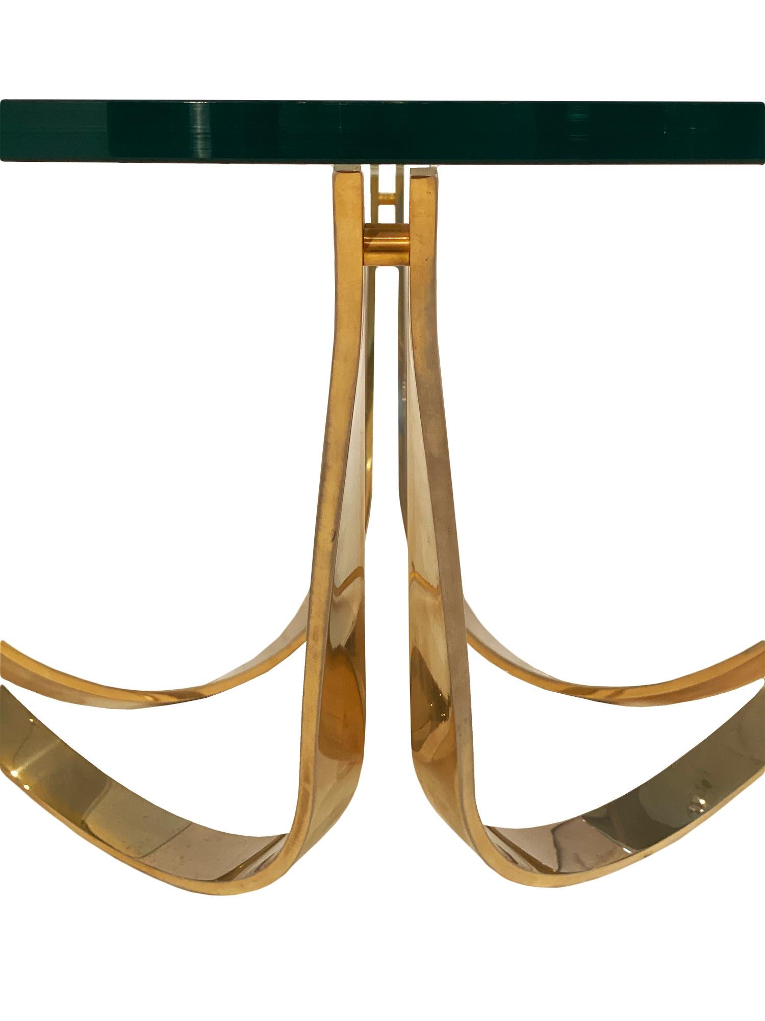 Vintage French coffee table featuring a strong gilt brass base shaped as interlaced bows. The top is a thick clear glass slab.