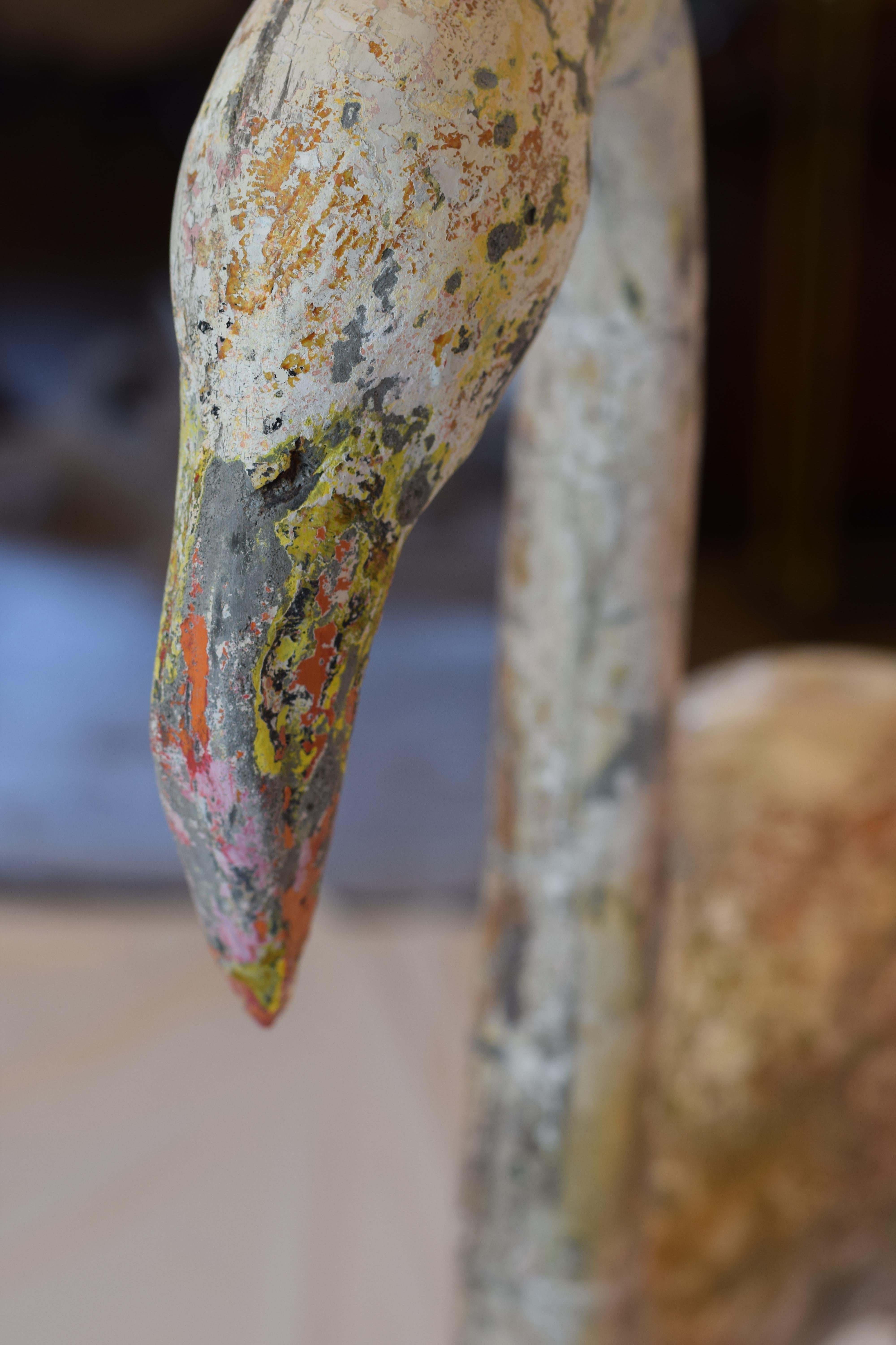 We found this colorful concrete flamingo in France. Heavy and sturdy, the concrete bird stands solidly on legs made of iron sunk into a concrete base. The body of the flamingo retains traces of the original paint which has been worn and dulled by