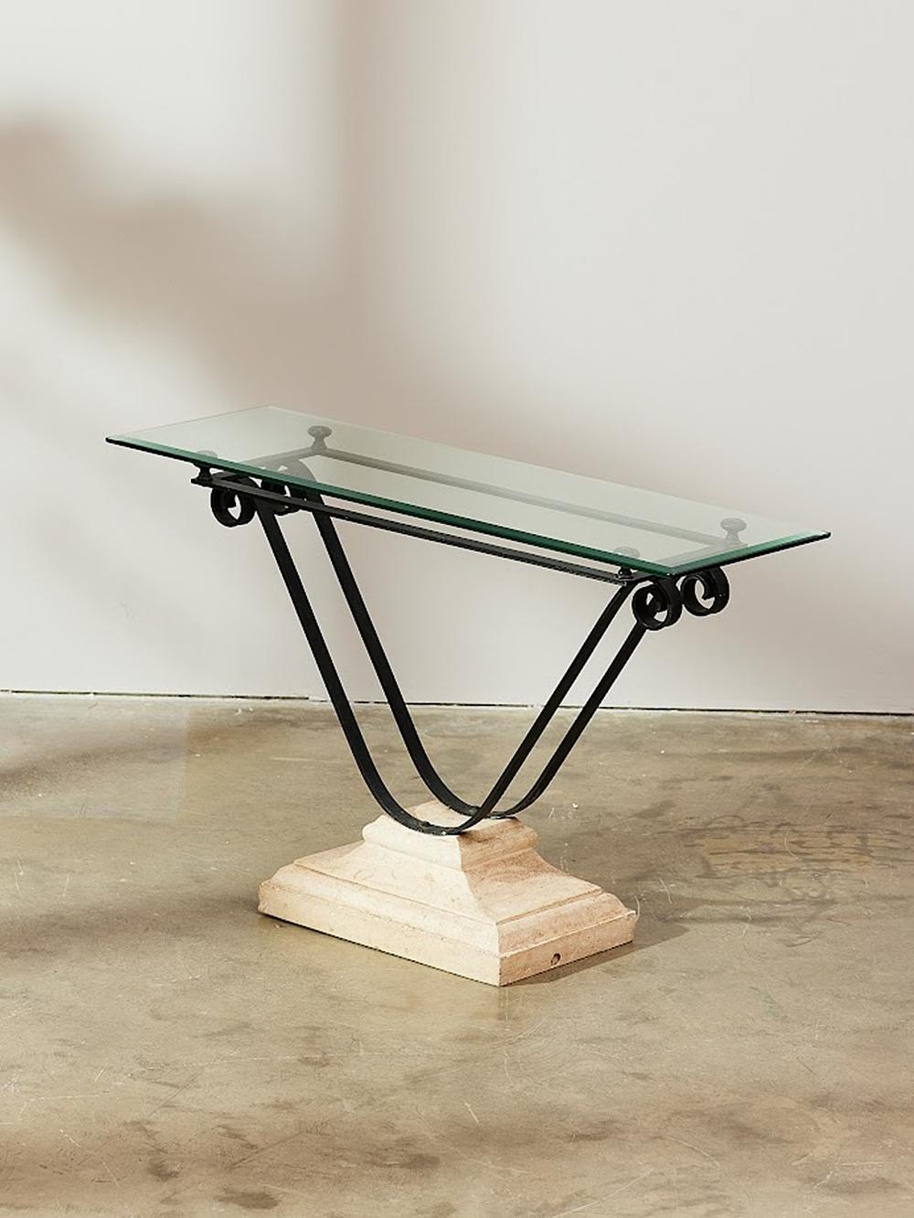 This vintage French console table from the 1980s offers a blend of elegance and functionality with timeless design in mind. The table stands 74 cm tall with an elegant glass table top that sits on a wide faux stone base, showcasing a sophisticated