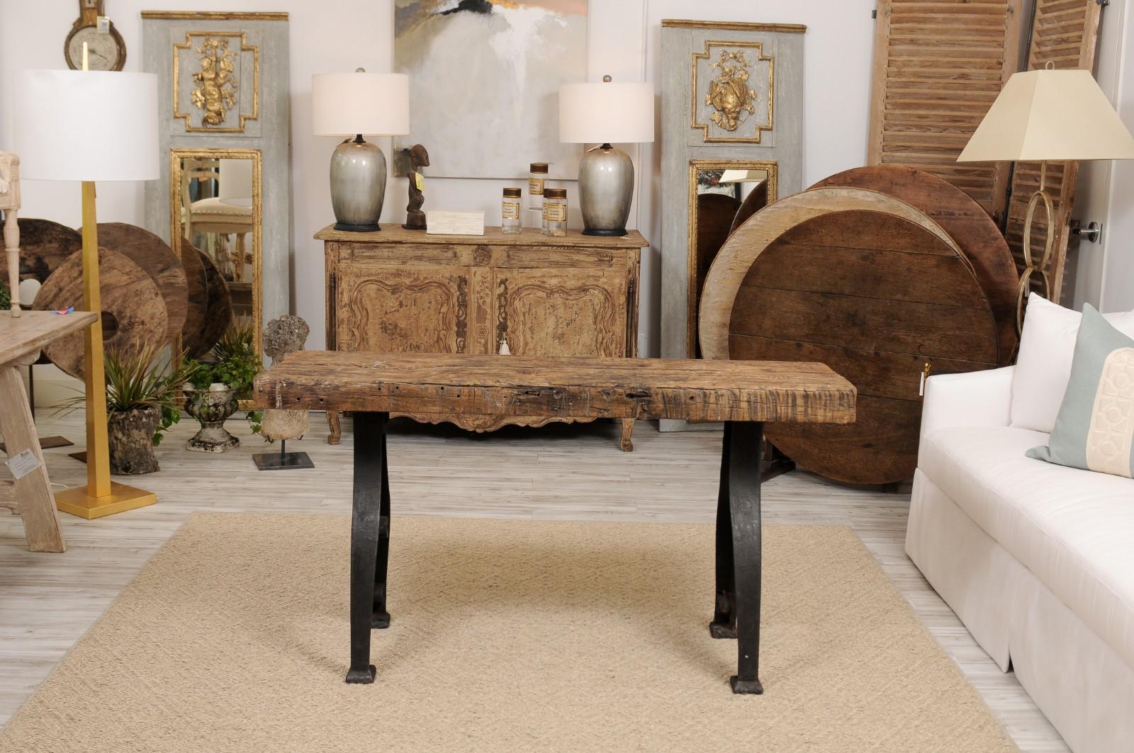 A French 1940s console table with thick rectangular oak top and Industrial wrought iron trestle base. We don’t often see slabs of oak that are this thick and handsome. Combined with a pretty wrought iron Industrial base, and this French midcentury
