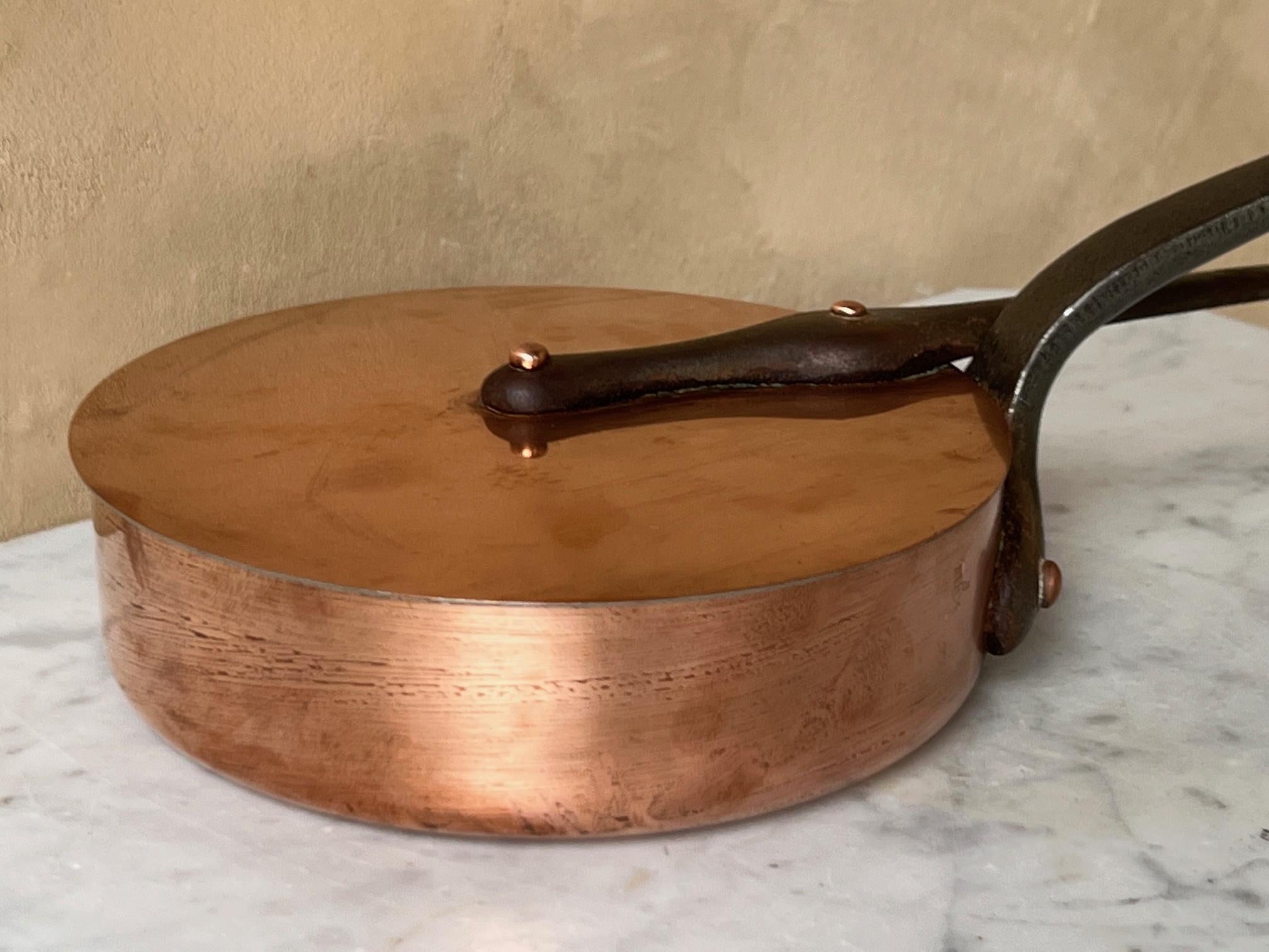 Vintage French copper saute pan and lid. The copper pot and handle have long cast iron handles with copper rivets and loops at the top for hanging each. Each piece has a layer of tin and ready to use.

The pan is stamped Cusinier

Pan measures 8