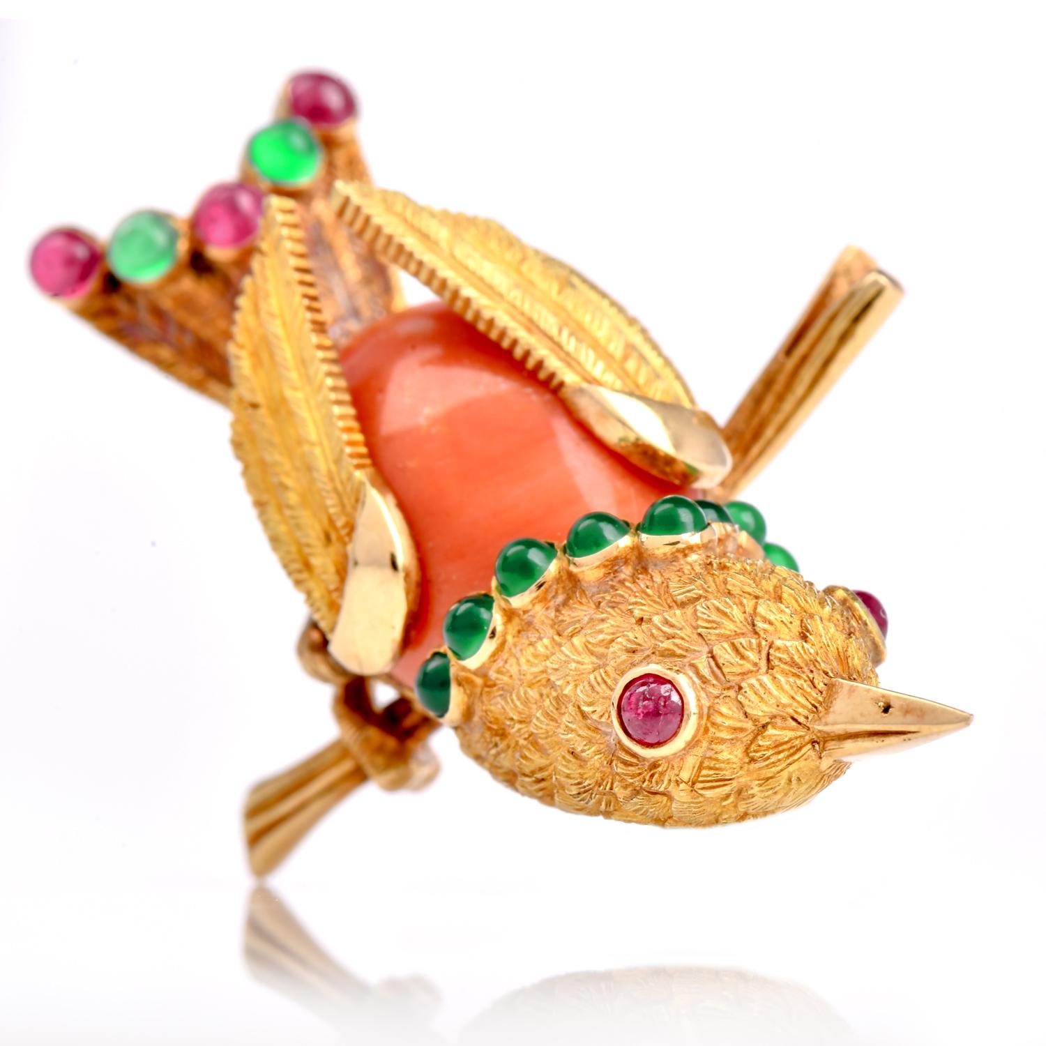 Presenting an exquisite vintage French brooch pin featuring a captivating bird motif, meticulously created from 18K yellow gold with a body crafted from rich coral and embellished with cabochon-cut rubies and emeralds, adding a touch of vibrant