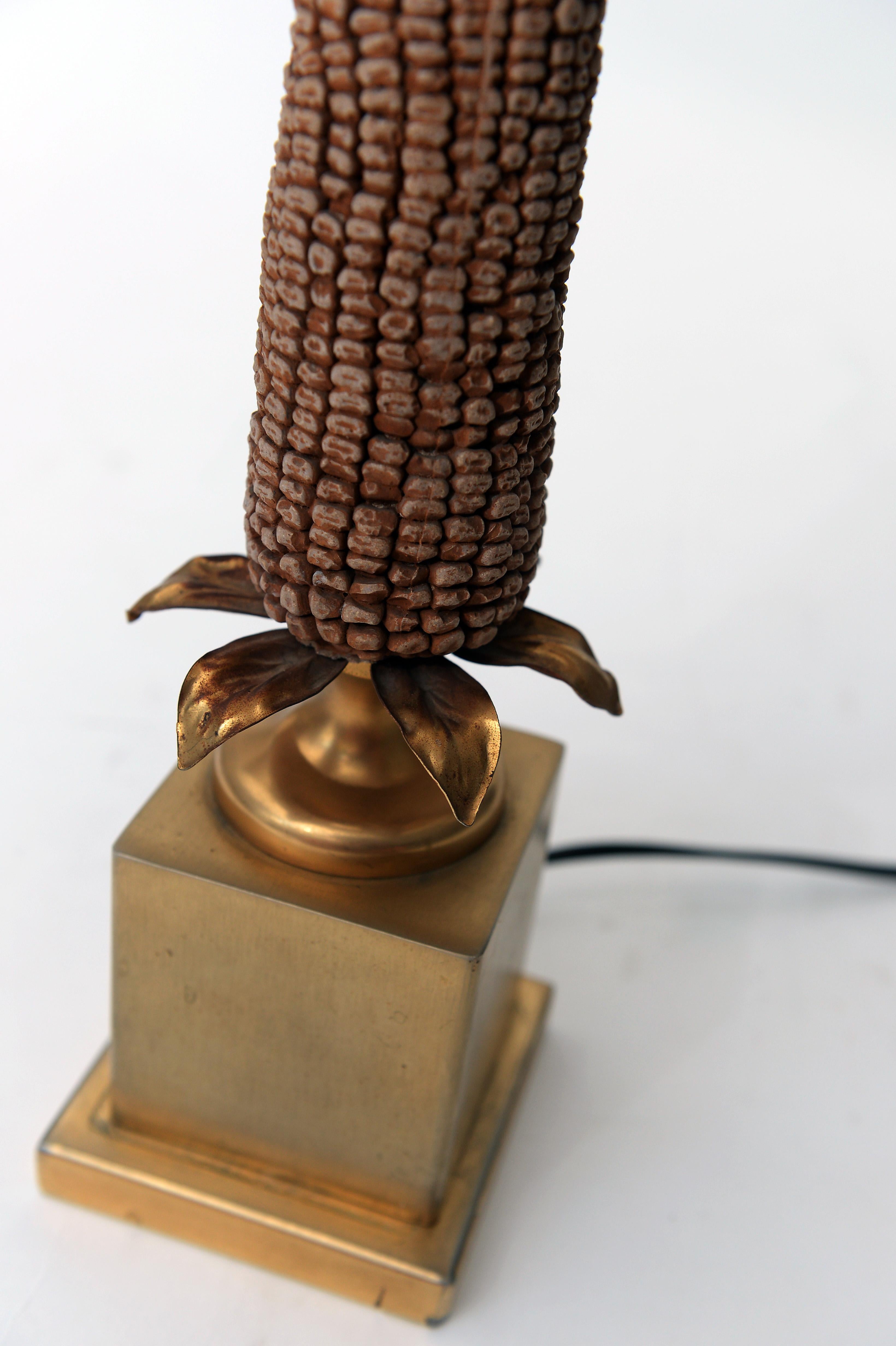 Charming corn table lamp in the style of Maison Charles.

The corn sculpture is made of resin and is highly detailed.

Brass is in good condition.

Comes with a black snake skin-like shade with a golden finish.

Lamp is tested and ready to