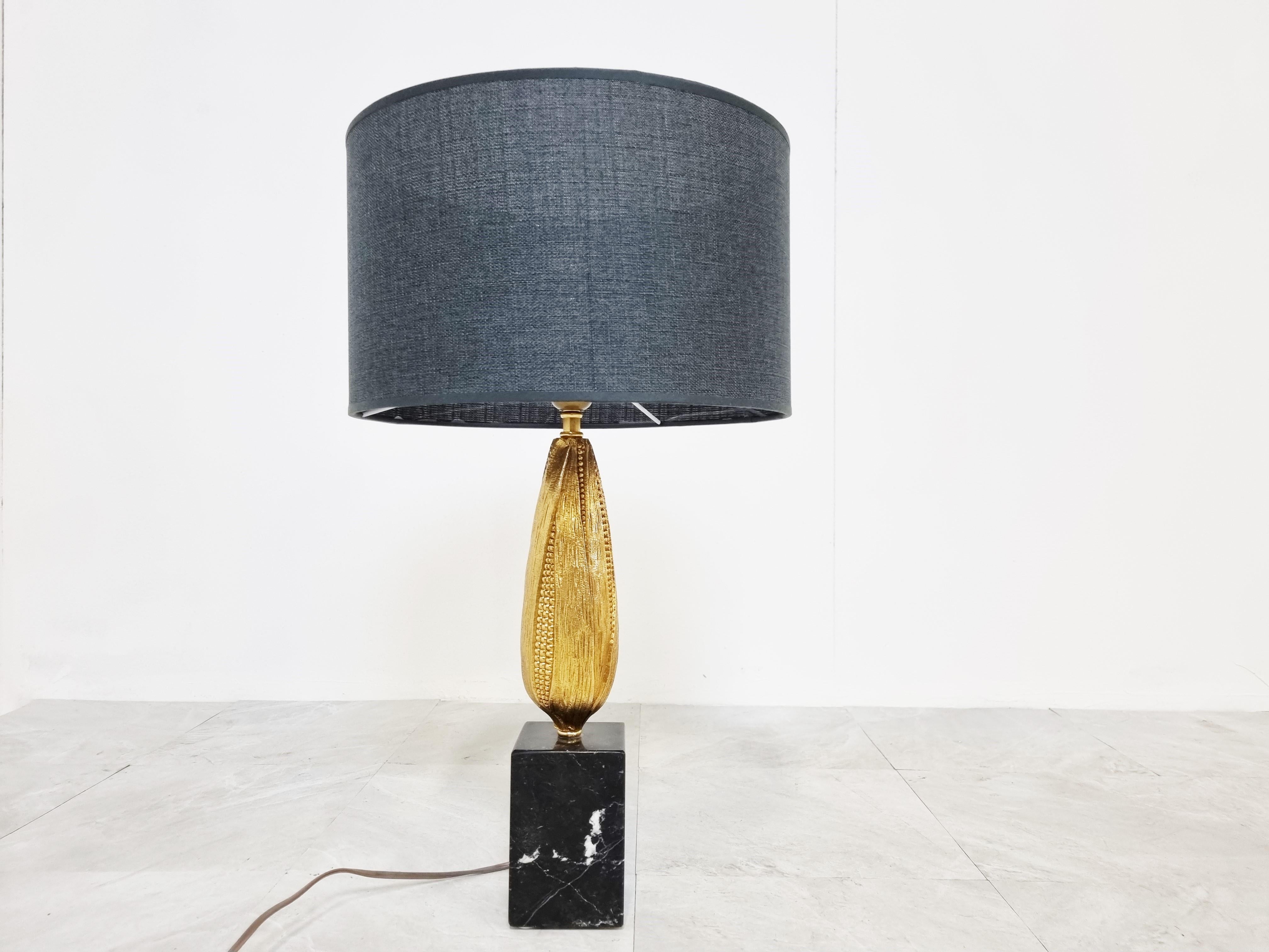 Charmante lampe à poser en forme de maïs.

La sculpture de maïs est fabriquée en laiton et est joliment détaillée.

Socle en marbre veiné noir et blanc et nouvel abat-jour.

La lampe est testée et prête à l'emploi avec une seule ampoule E27.