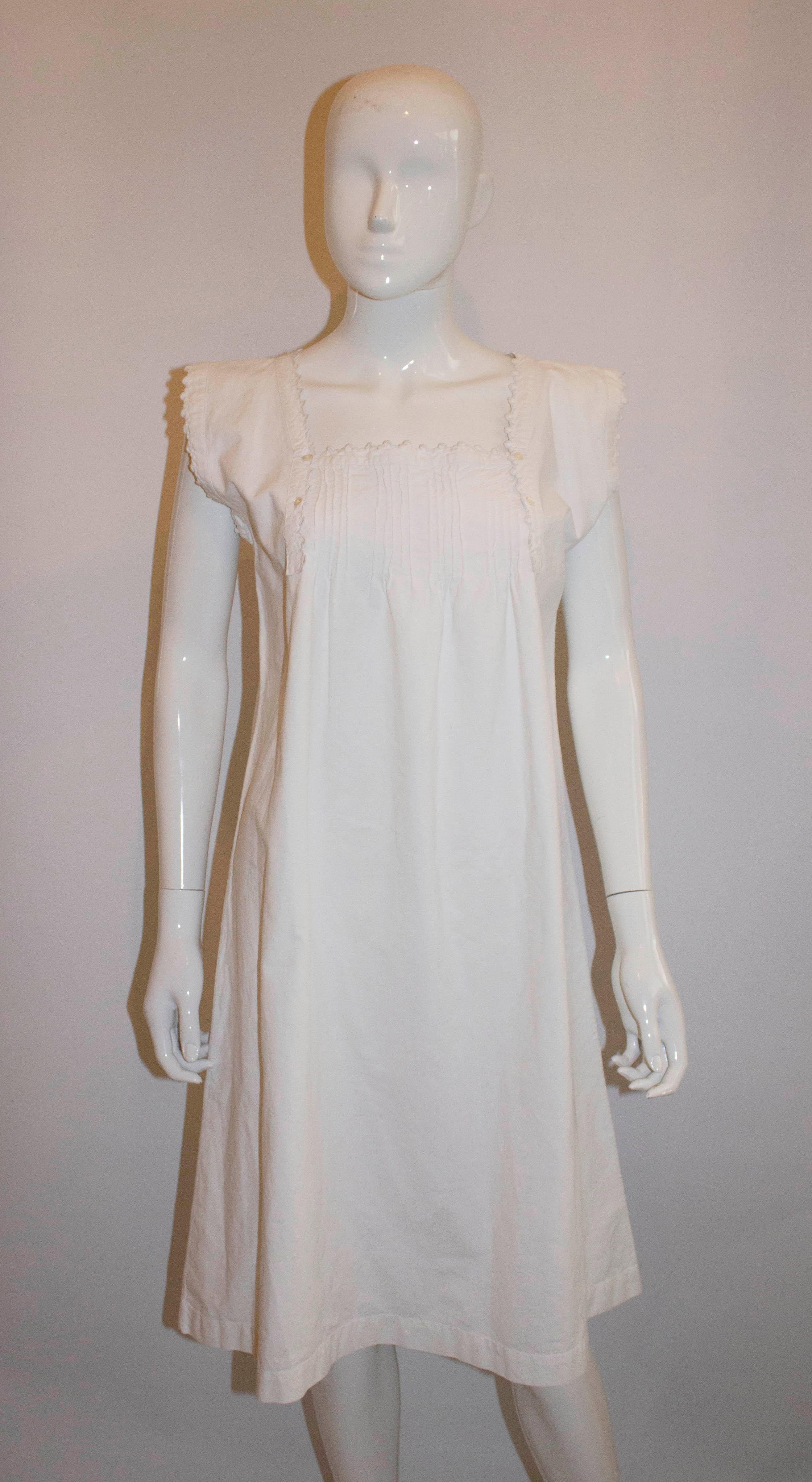Ein tolles Vintage-Kleid für den Sommer. Dieses Vintage-Kleid aus Frankreich ist aus schwerer Baumwolle gefertigt und hat einen tiefen, quadratischen Ausschnitt und Biesen auf der Vorderseite. Es hat dekorative Einfassungen entlang der Vorder- und
