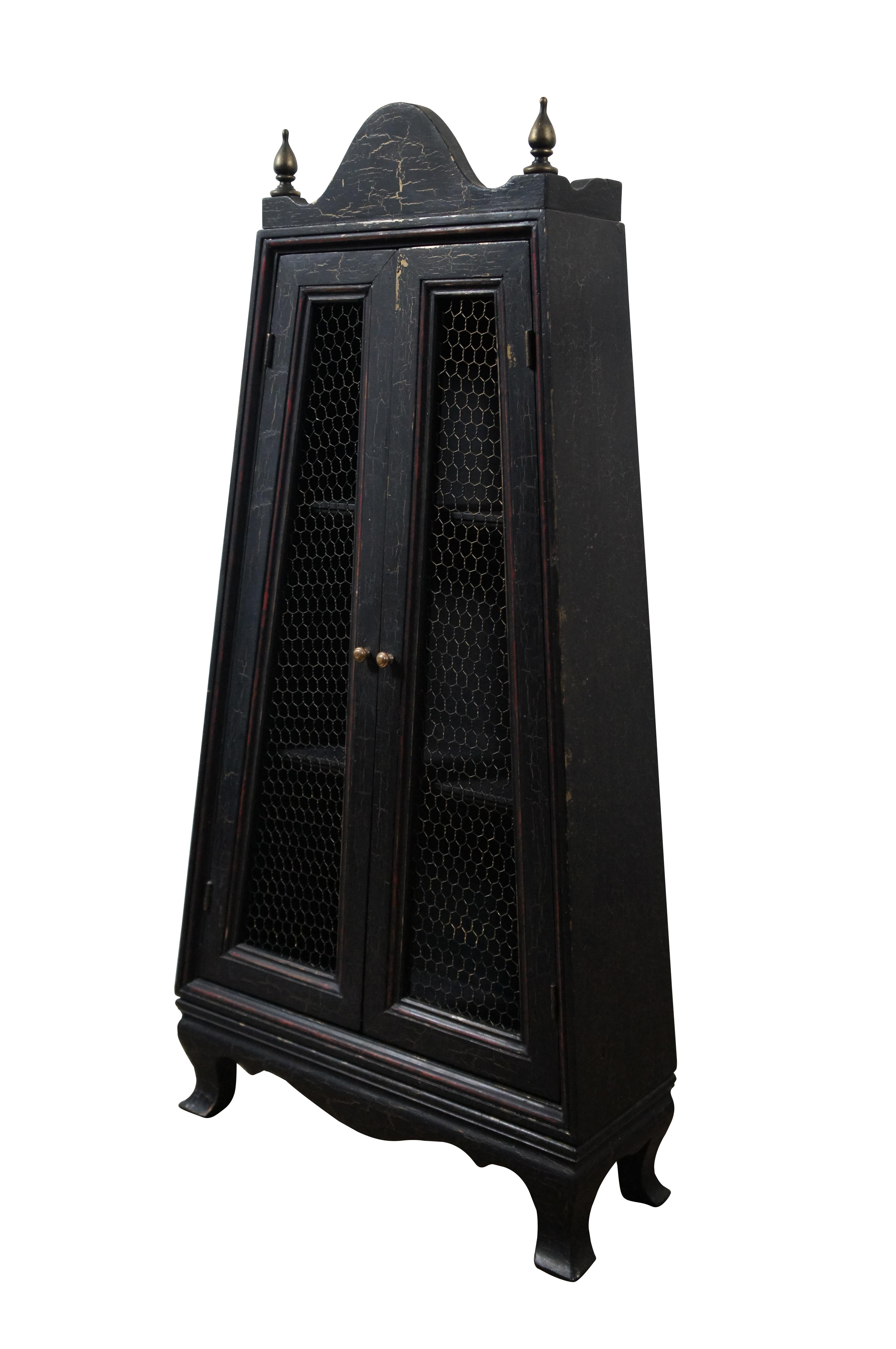 Vintage wall hanging curio display cabinet.  Made of wood featuring French Country styling with black and red crackle paint finish, serpentine accents, gold finials and chicken wire doors.

Dimensions:
17” x 6” x 24.5” (Width x Depth x Height)