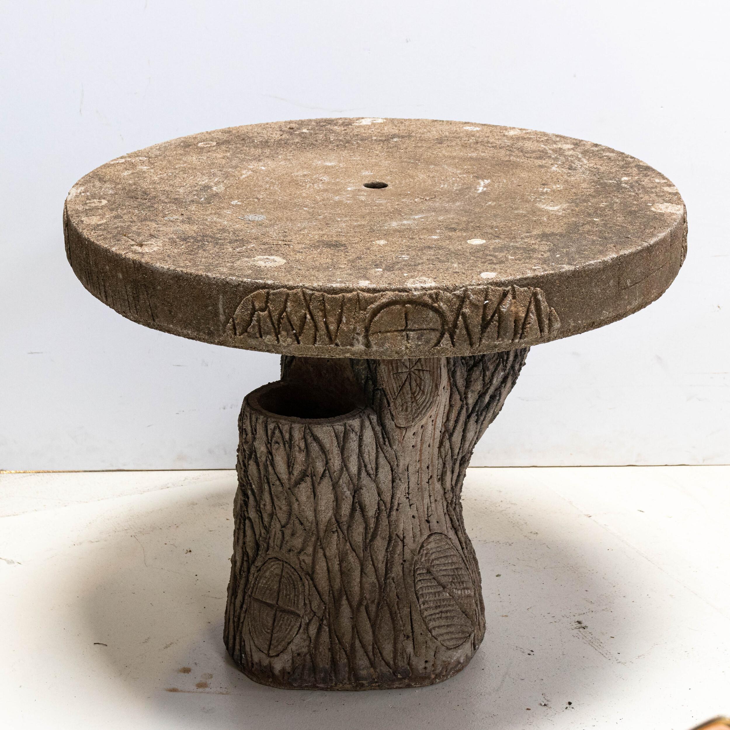 Whimsical cast stone round outdoor patio table with a stylized faux bois base, made in France, circa early 20th century. Round slab tabletop is supported by a sturdy base in the shape of a tree stump. The base has nicely detailed bark that adds