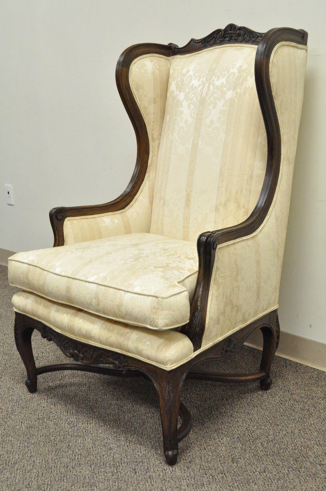 Great quality vintage Country French / Louis XV style lounge chair and ottoman. Item features tall wingback design, solid floral carved walnut frame, X-Form stretcher supports, matching solid carved walnut ottoman, circa mid-20th century,