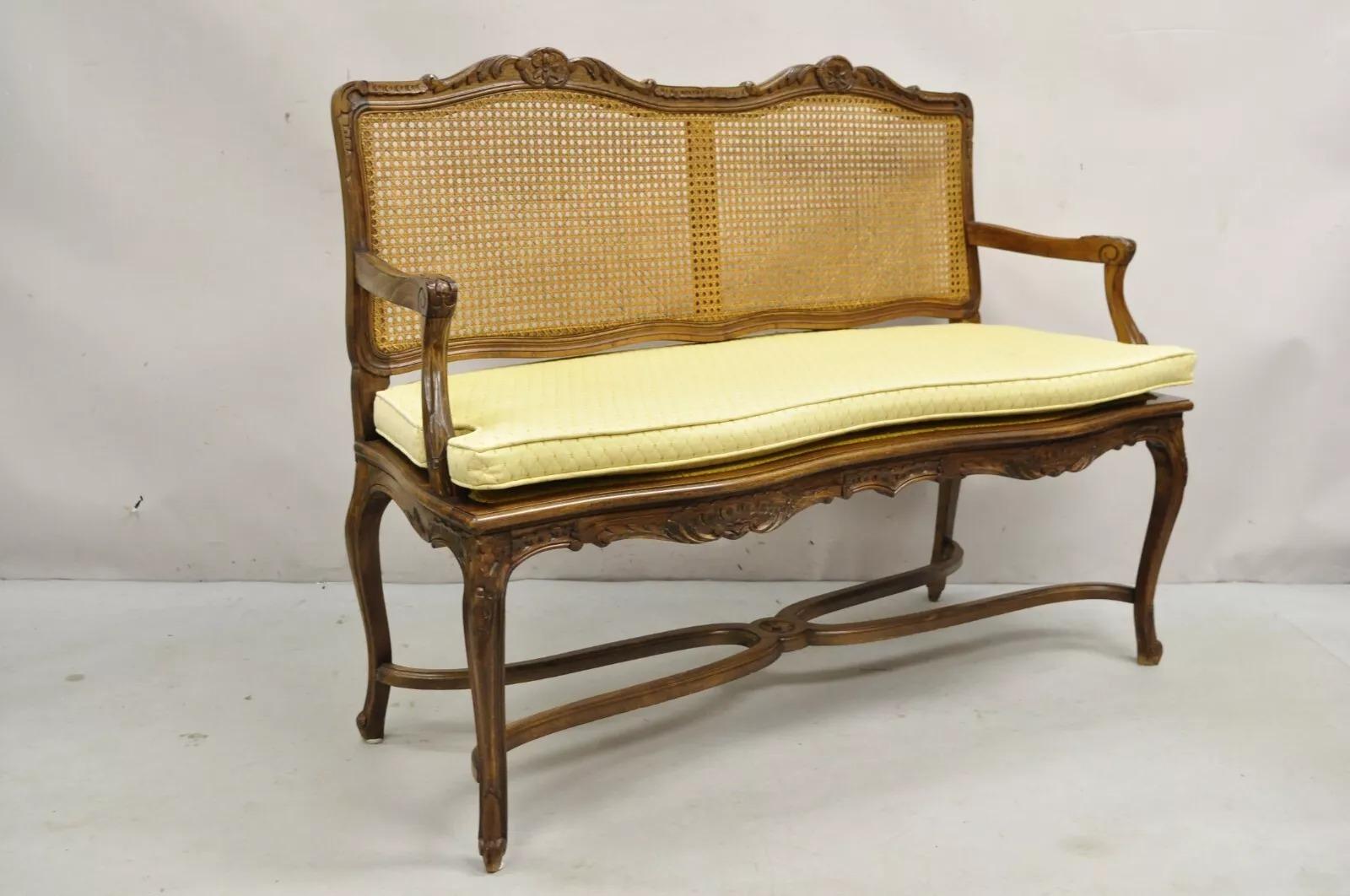 Vintage French Country Provincial Louis XV Style Carved Wood Cane Back Bench Settee wth Stretcher Base and Yellow Loose Cushion. Circa Mid 20th Century. Measurements: 38
