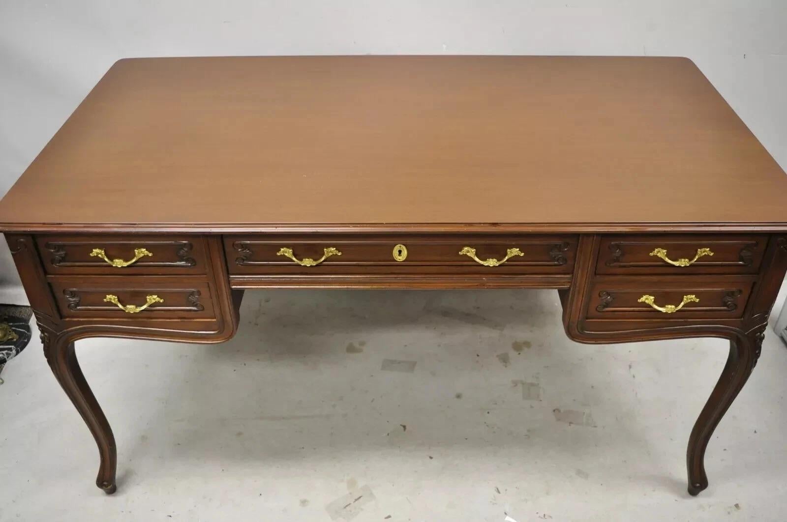 Vintage French Country Provincial Louis XV Style Walnut Office Writing Desk. Item features a custom glass top, solid wood construction, lightly distressed finish, nicely carved details, finished back, 5 dovetailed drawers, cabriole legs, solid brass