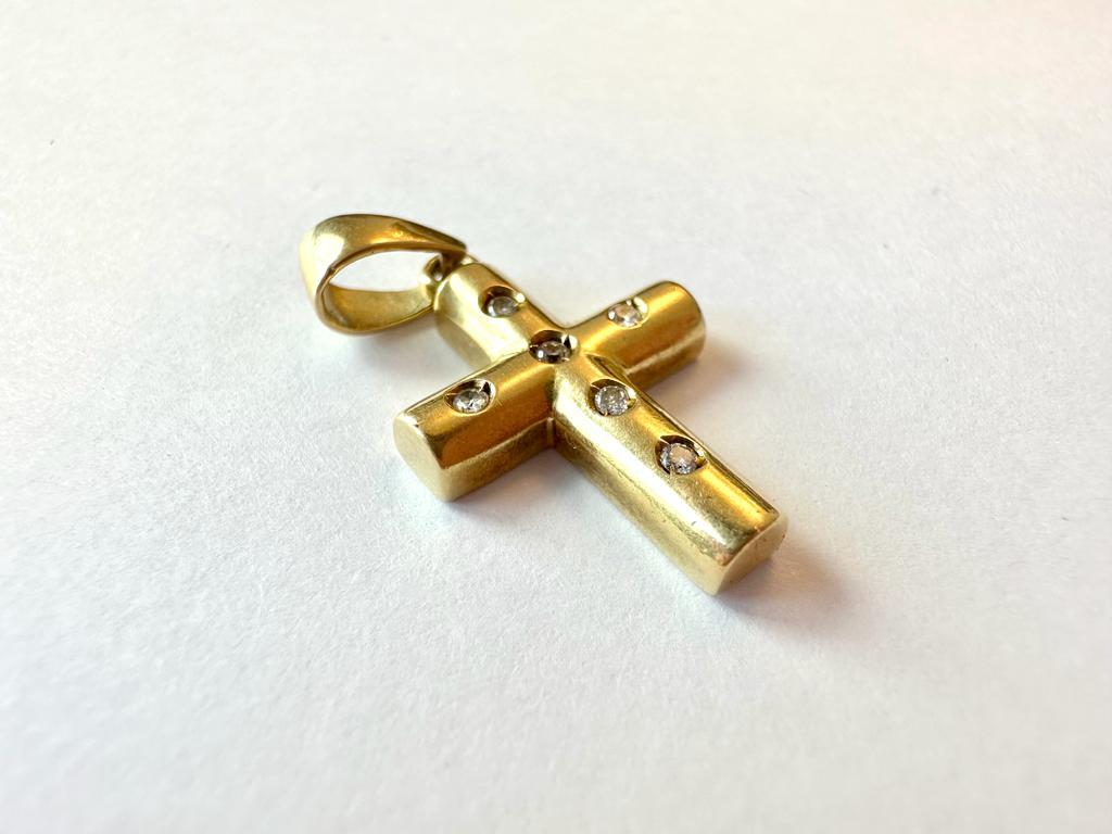 Ce magnifique pendentif présente une finition satinée. Réalisée en or jaune 18kt, cette croix est de production française et est ornée de 6 diamants taille brillant pour un total de 0,18ct. Le satinage est une technique qui permet de ternir la