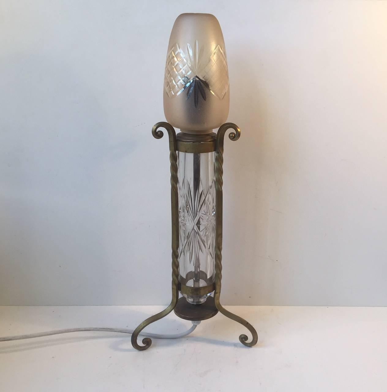 A handcrafted French table light composed of twisted/swirled brass, etched tubular crystal centerpiece and a colored, matte and partially etched shade. This lamp was manufactured in France during the 1940s or 1950s. It is mounted with newer wiring